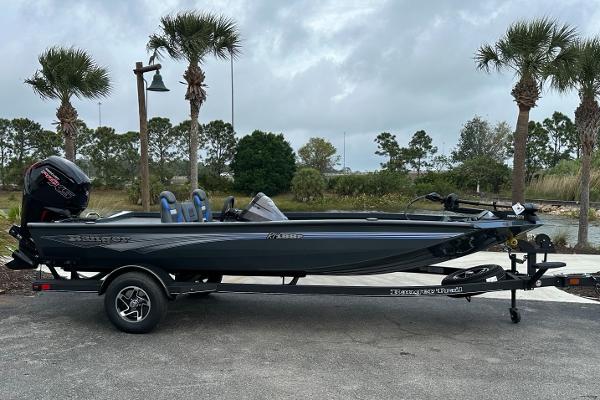 2025 Ranger RT188P boat on trailer, parked near palm trees under cloudy sky.