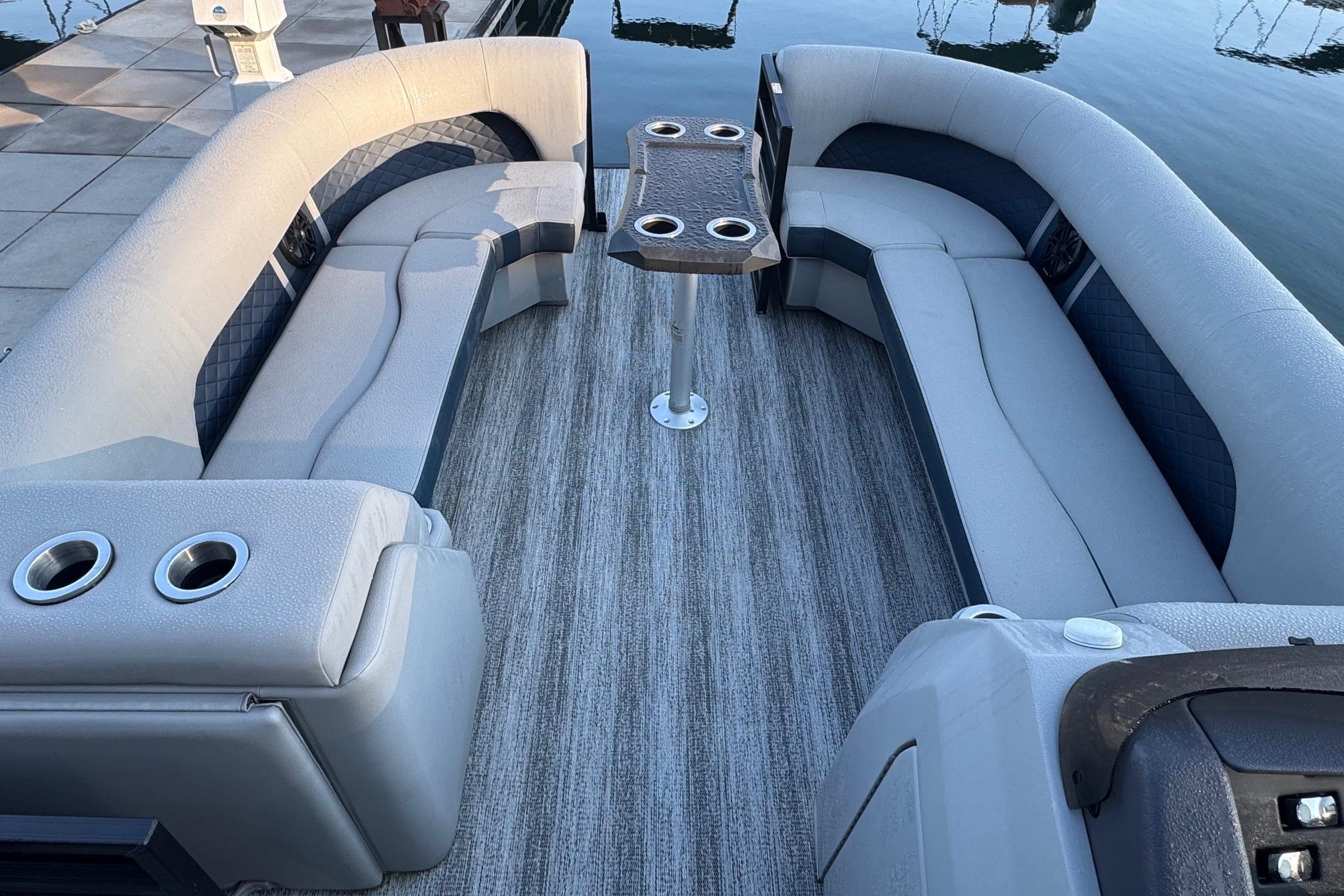 Luxurious seating area on 2025 Bennington 26 L Top Deck pontoon boat with cup holders.