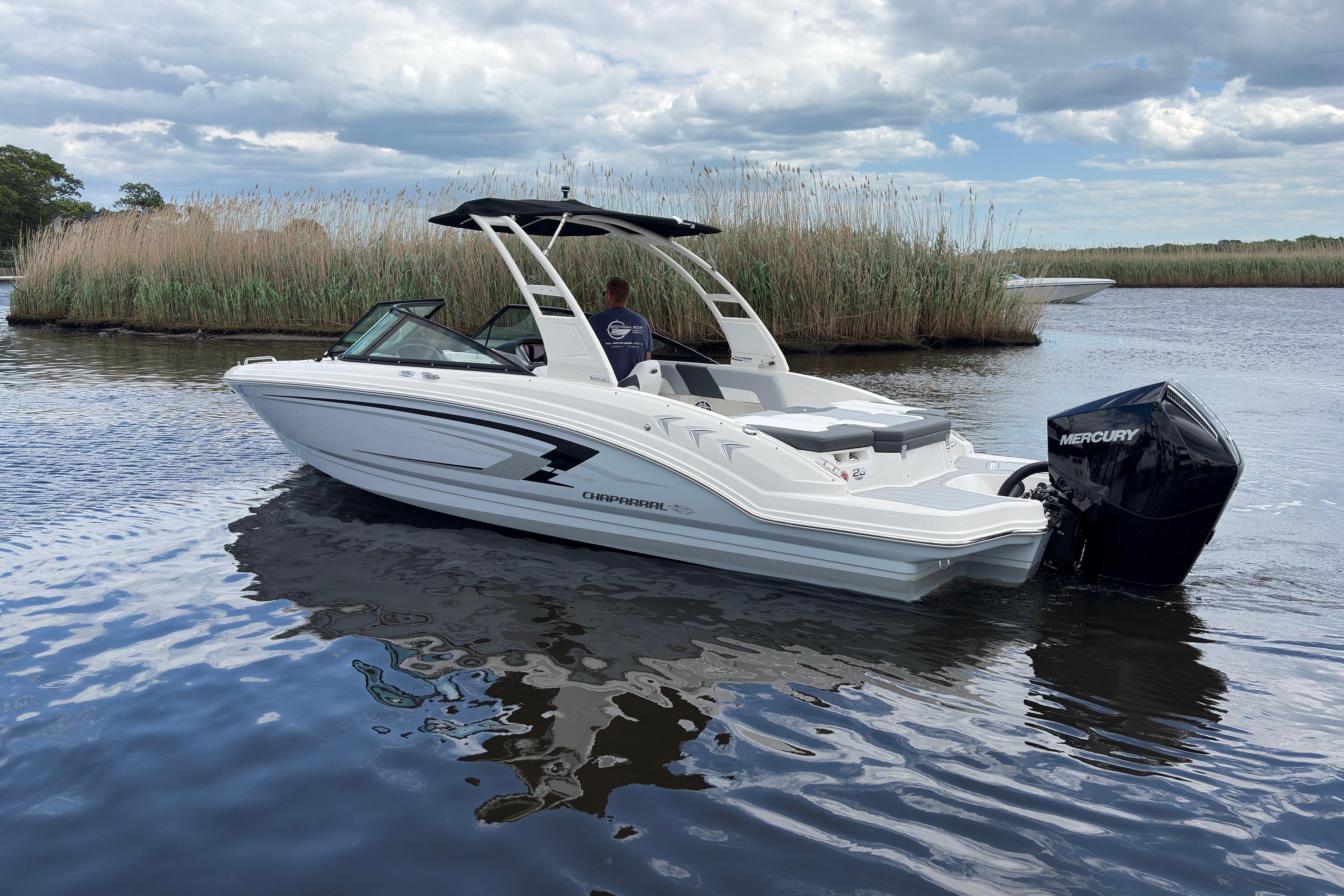 2026 Chaparral 23 SSi OB boat on calm water, featuring sleek design and Mercury outboard engine.