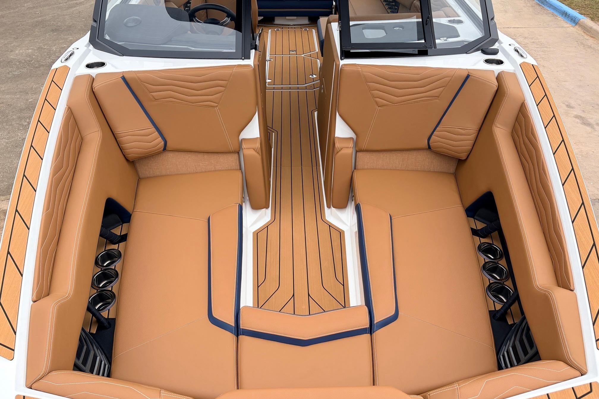 2026 Nautique Super Air Nautique G25 interior with tan leather seating and cup holders.