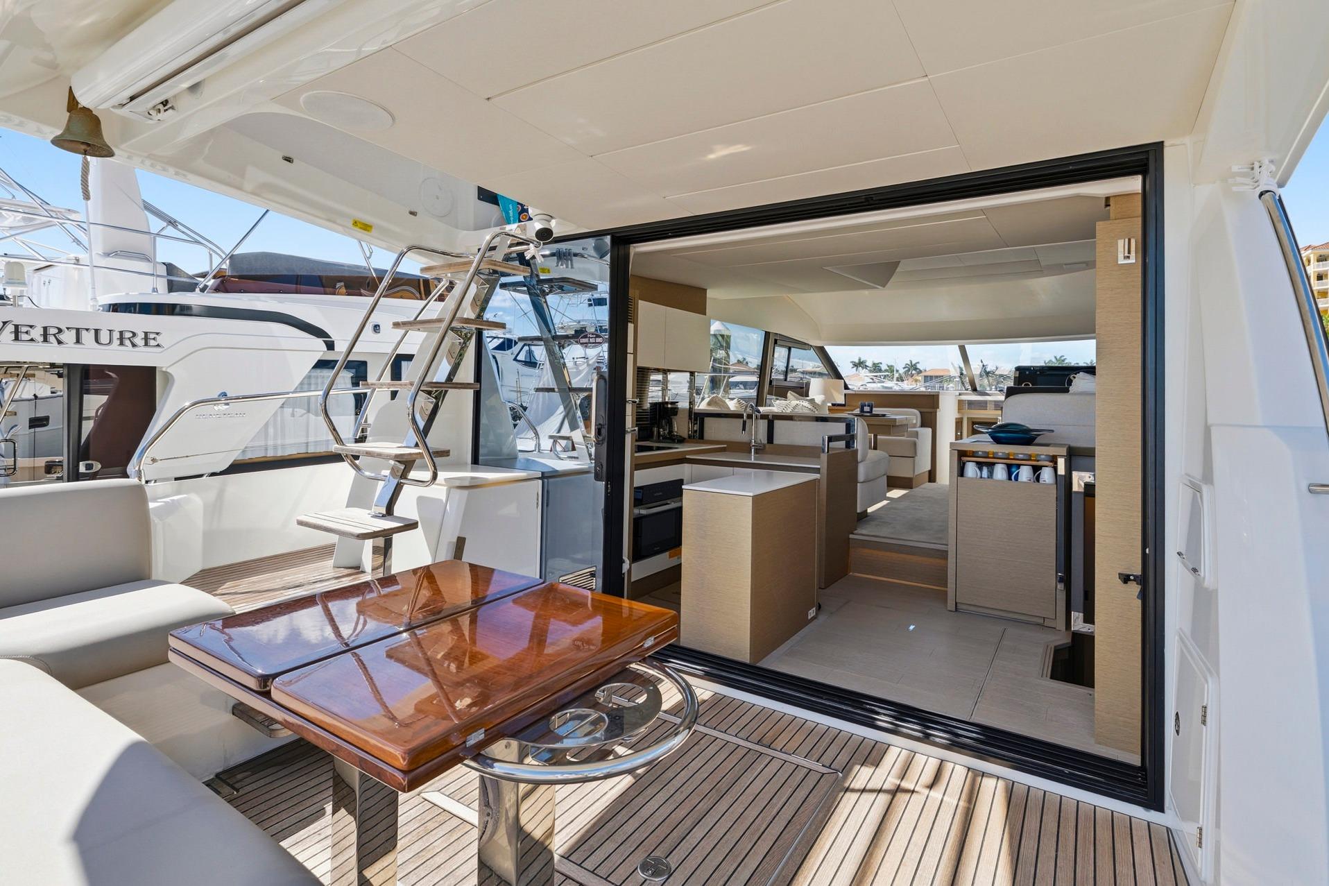 Luxurious 2022 Prestige 520 yacht interior with modern kitchen and seating area.