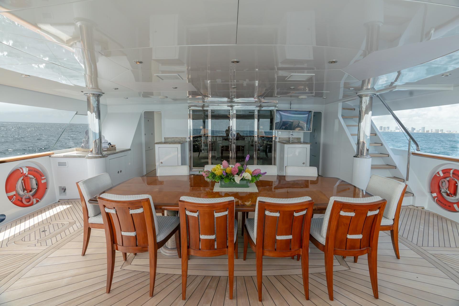 Luxurious 2006 Trinity Tri-Deck Motor Yacht dining area with ocean view and elegant seating.