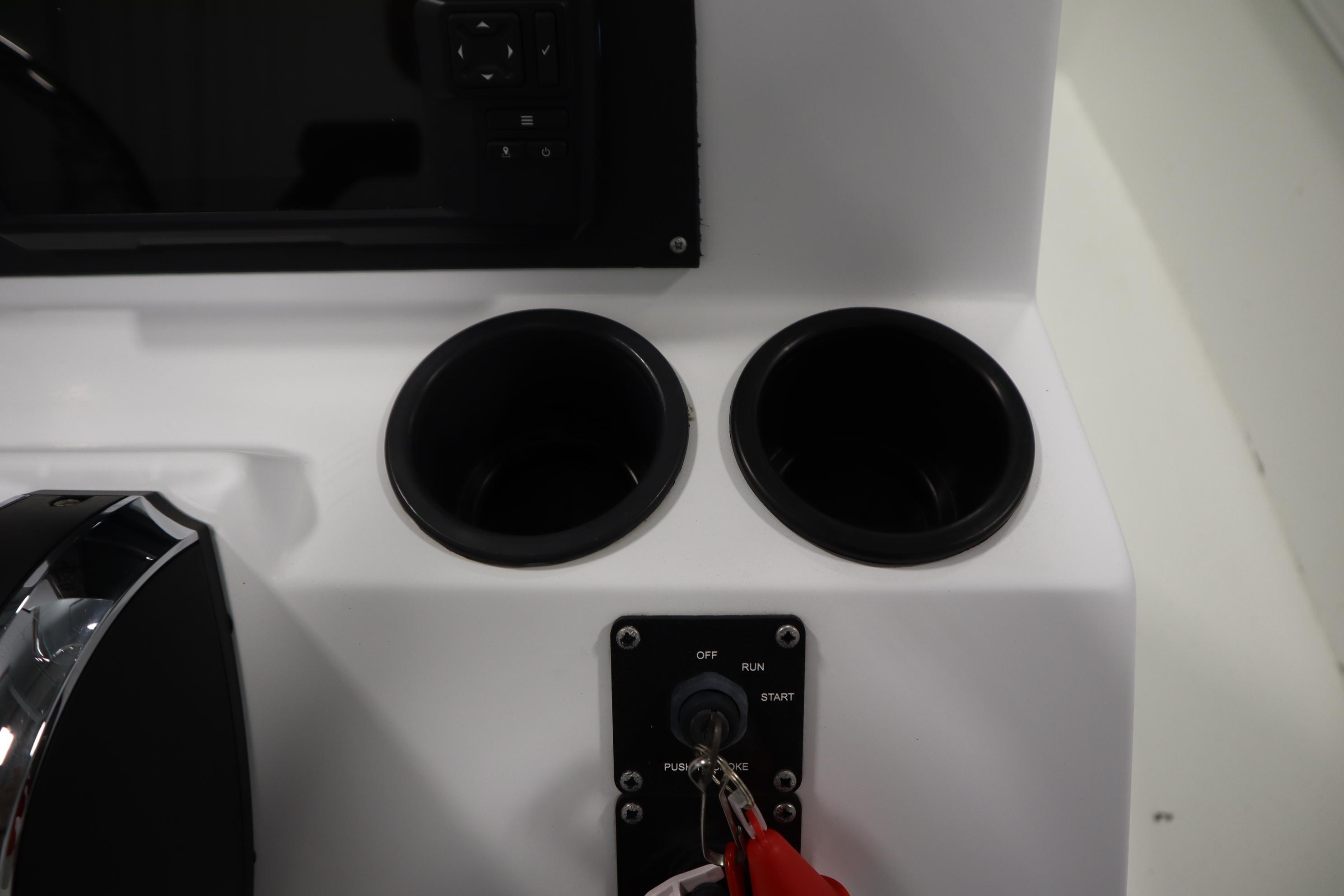 2022 Crestliner 2200 CC boat console with cup holders and ignition switch.
