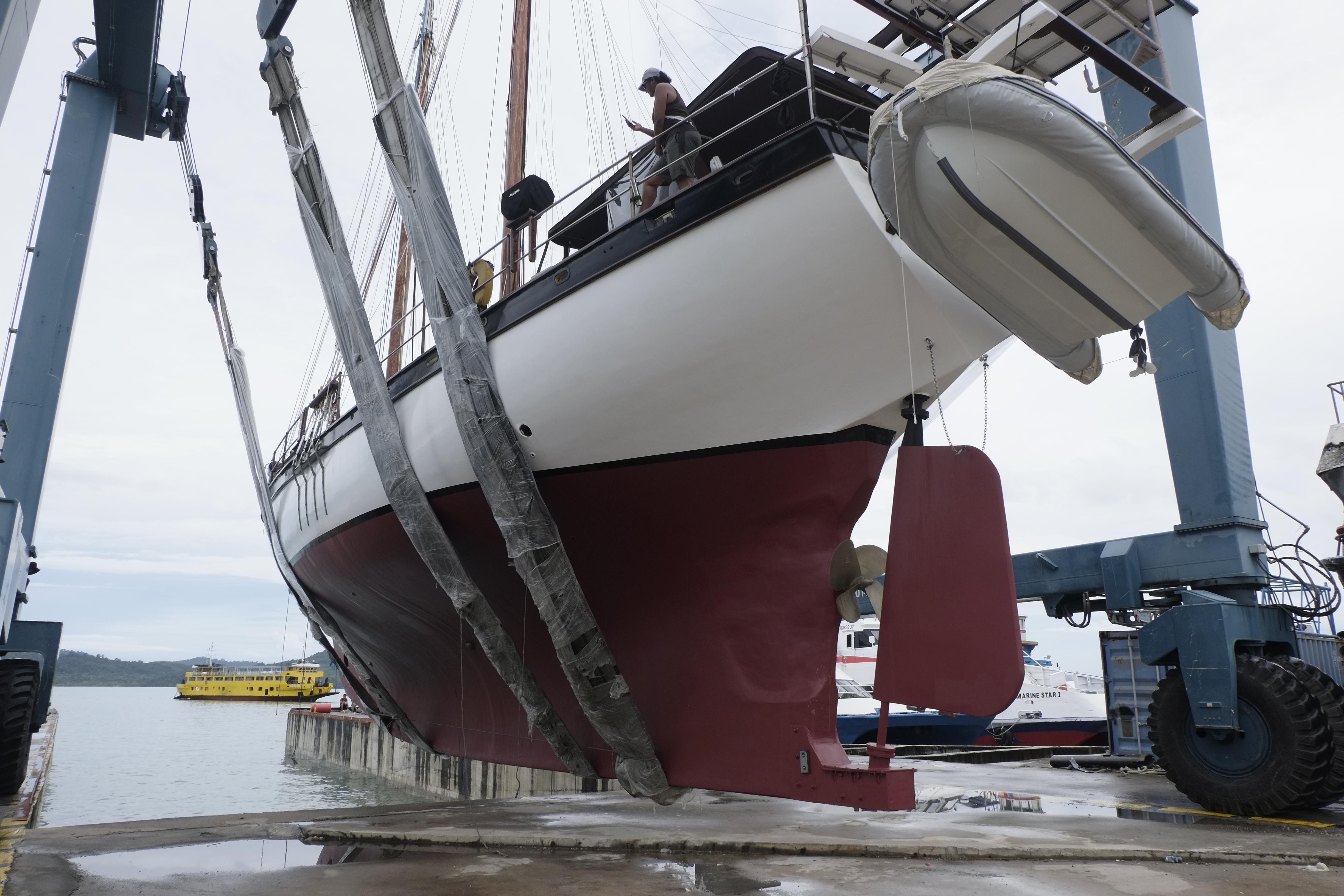 Custom Bud Macintosh schooner, 2006, being lifted by a crane at a dockside.