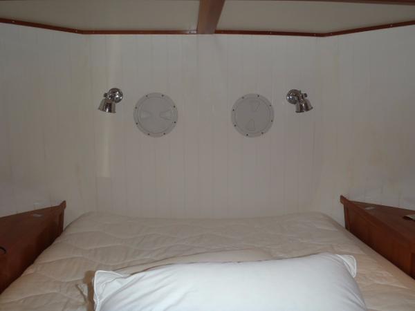 Cozy cabin interior of 2025 Great Harbour N40 with bed and porthole windows.