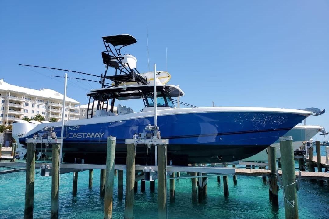 2019 HCB 42 Siesta boat docked, vibrant blue hull, clear water, sunny day.