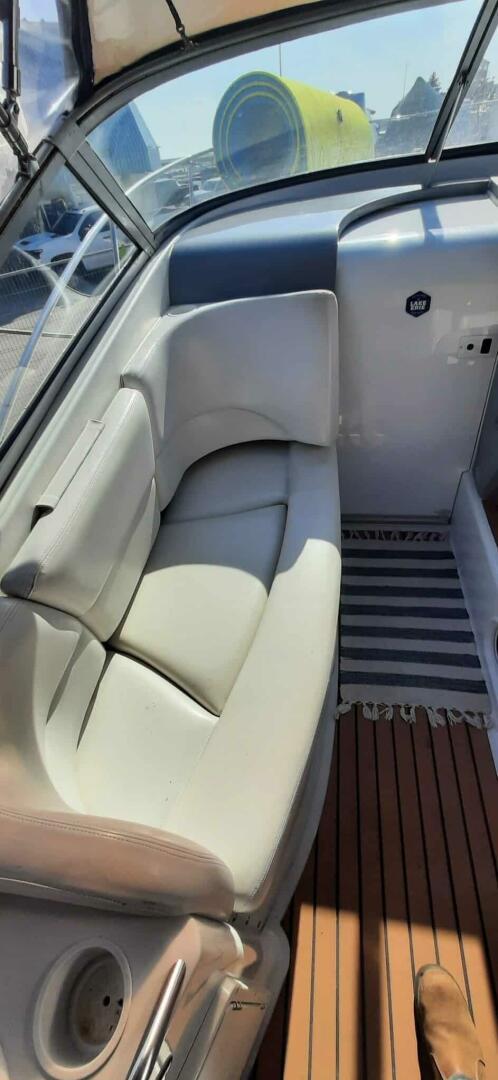 2000 Four Winns 298 Vista boat interior with cushioned seating and striped rug.