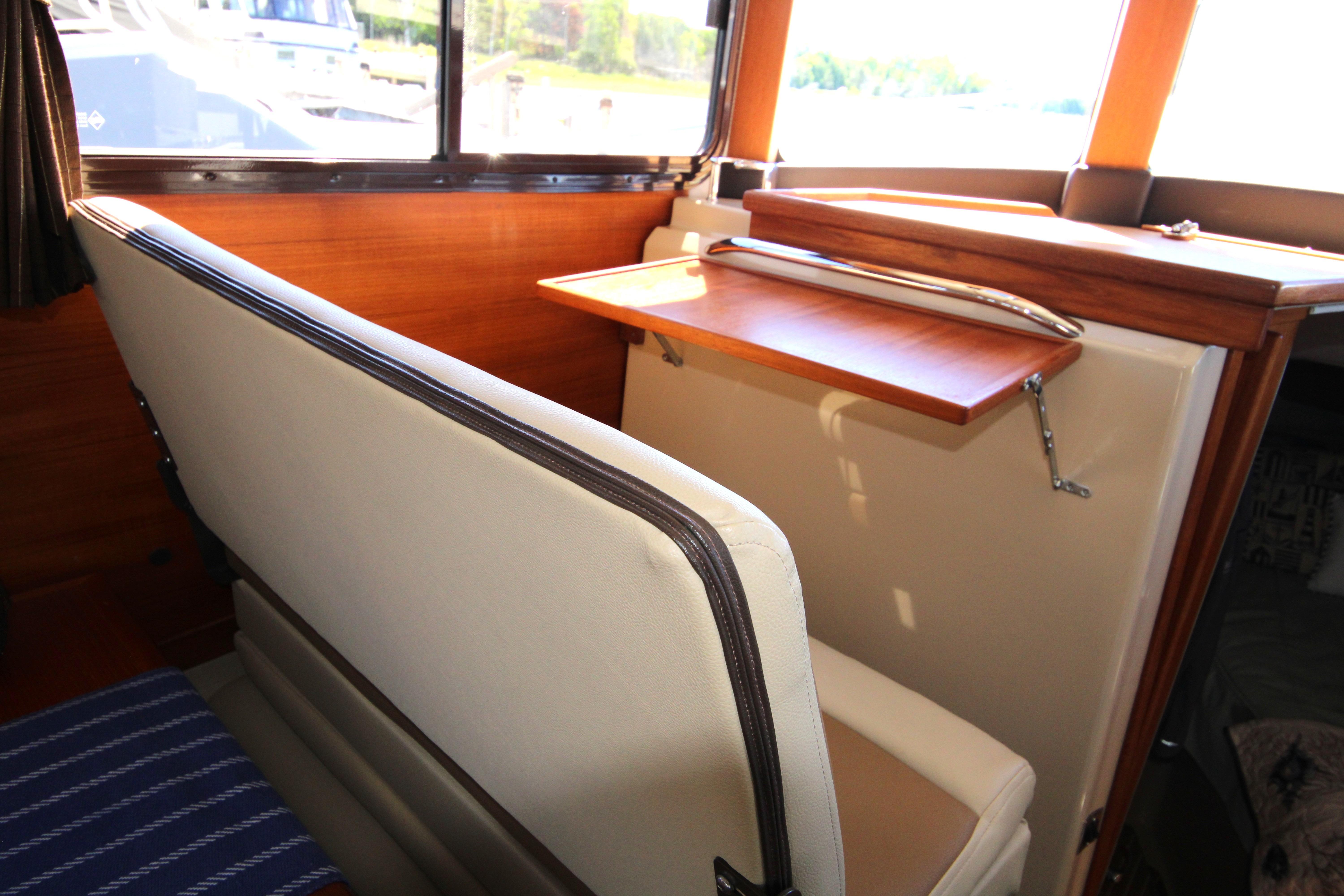 Interior of 2013 Ranger Tugs R-31 CB with foldable wooden table and cushioned seating.