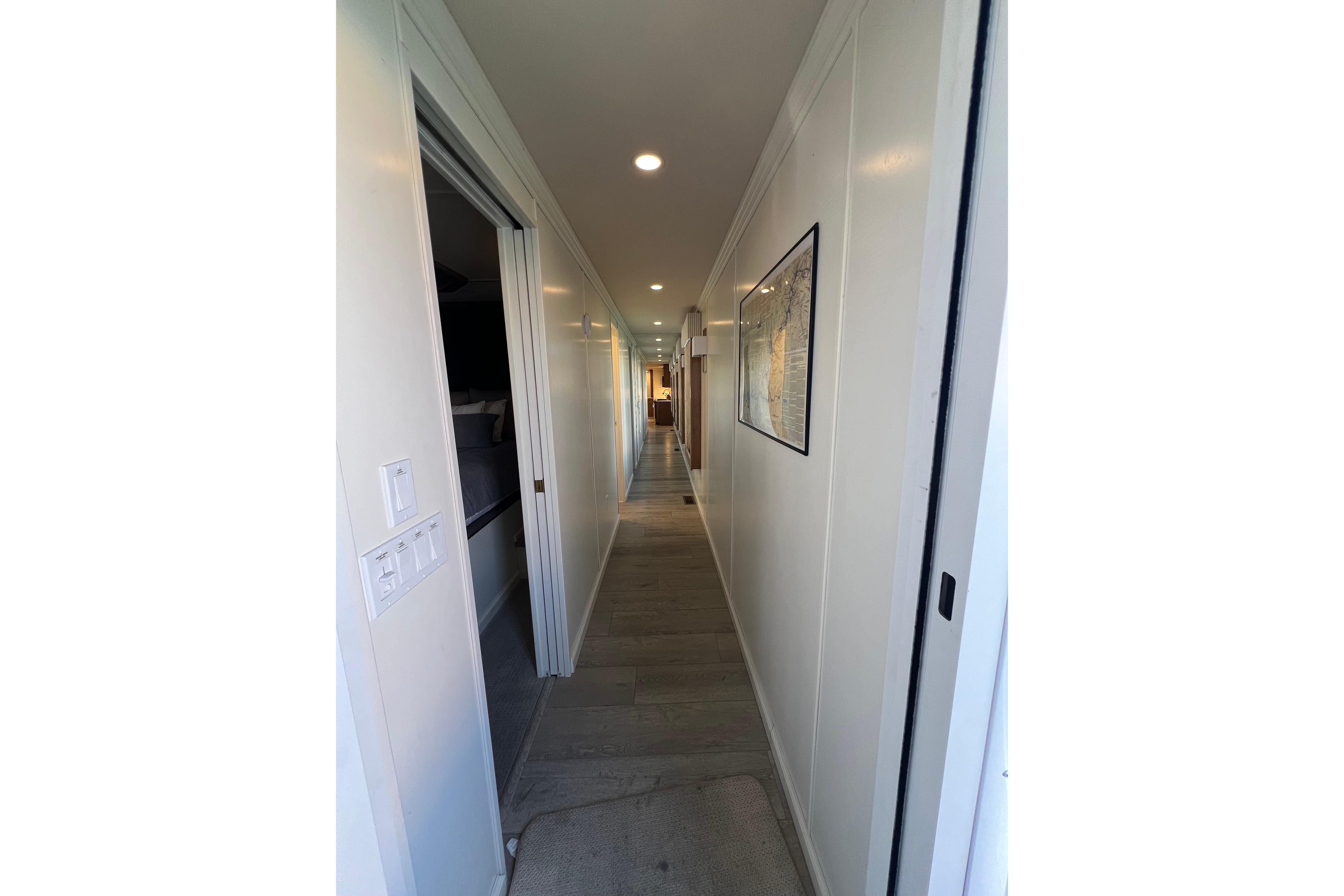 Narrow hallway inside 2025 Sumerset Excellence Multiple Shares houseboat, featuring modern lighting and decor.