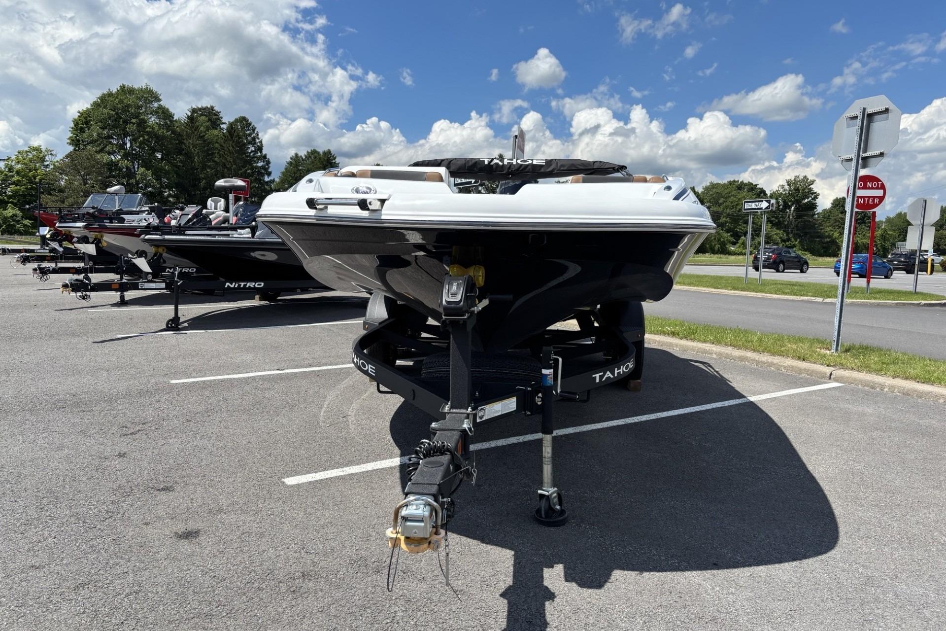 2026 Tahoe 1950 boat on trailer in parking lot under blue sky.