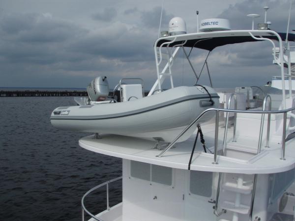 2025 Great Harbour N40 yacht with dinghy on deck, moored under cloudy skies.