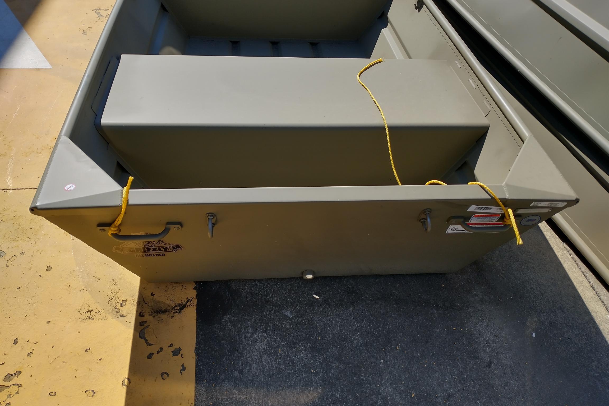 2026 Tracker Grizzly 12 Jon boat, olive green, secured with yellow ropes.