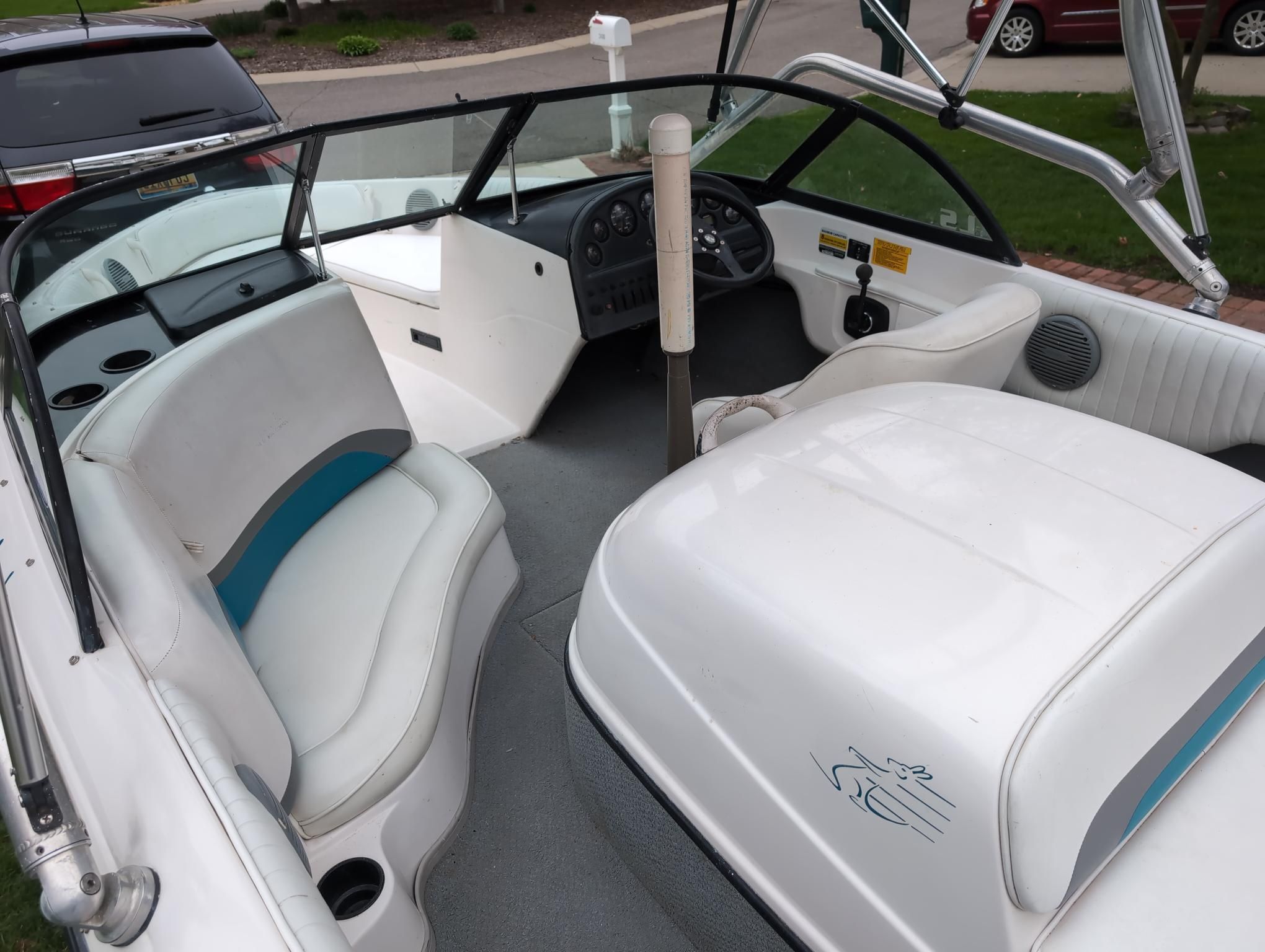 The image shows the cockpit of a 2000 Moomba Ouback LS with white seats and a helm.