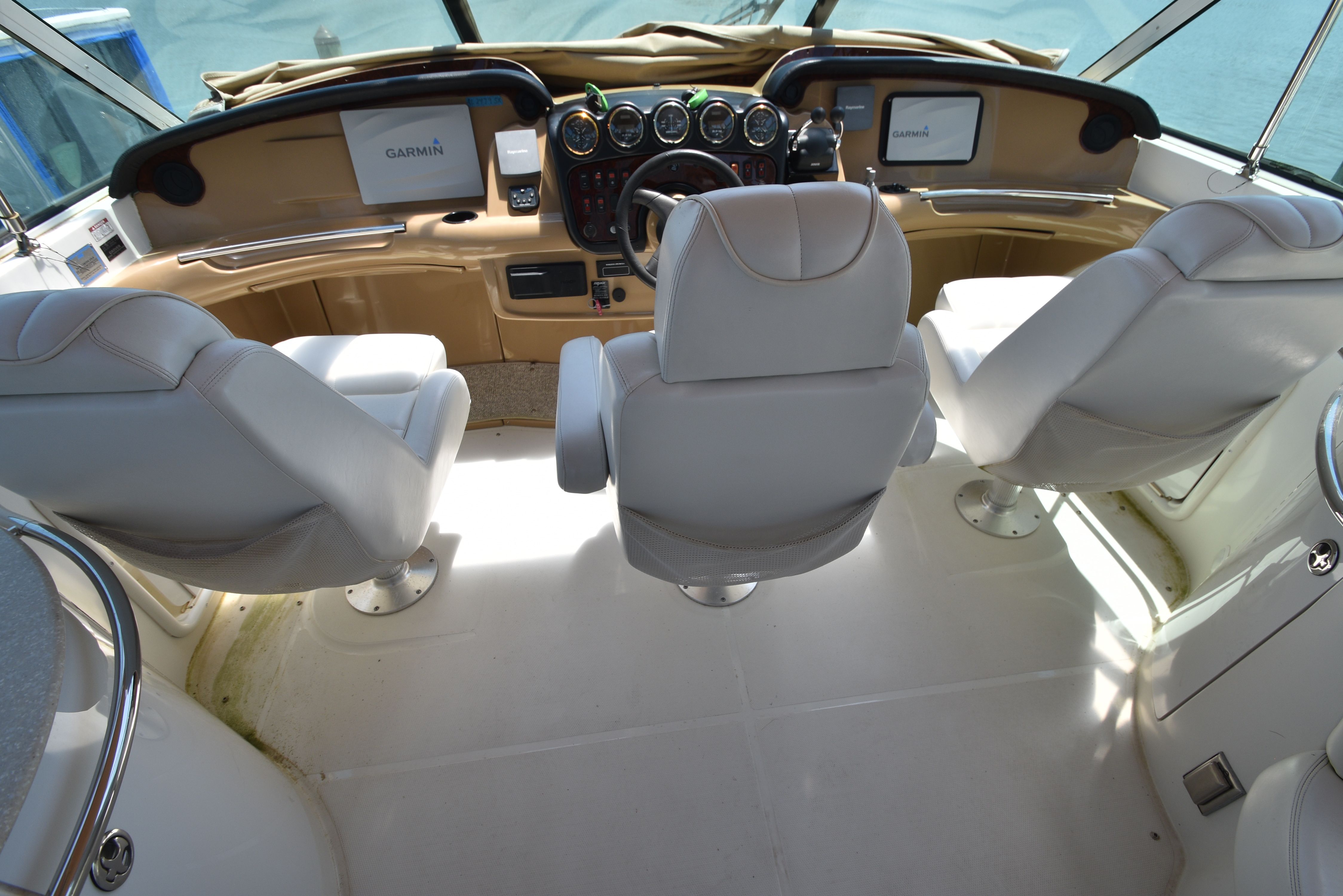 Interior of the 2004 Carver 466 Motor Yacht with three white seats and a helm station.