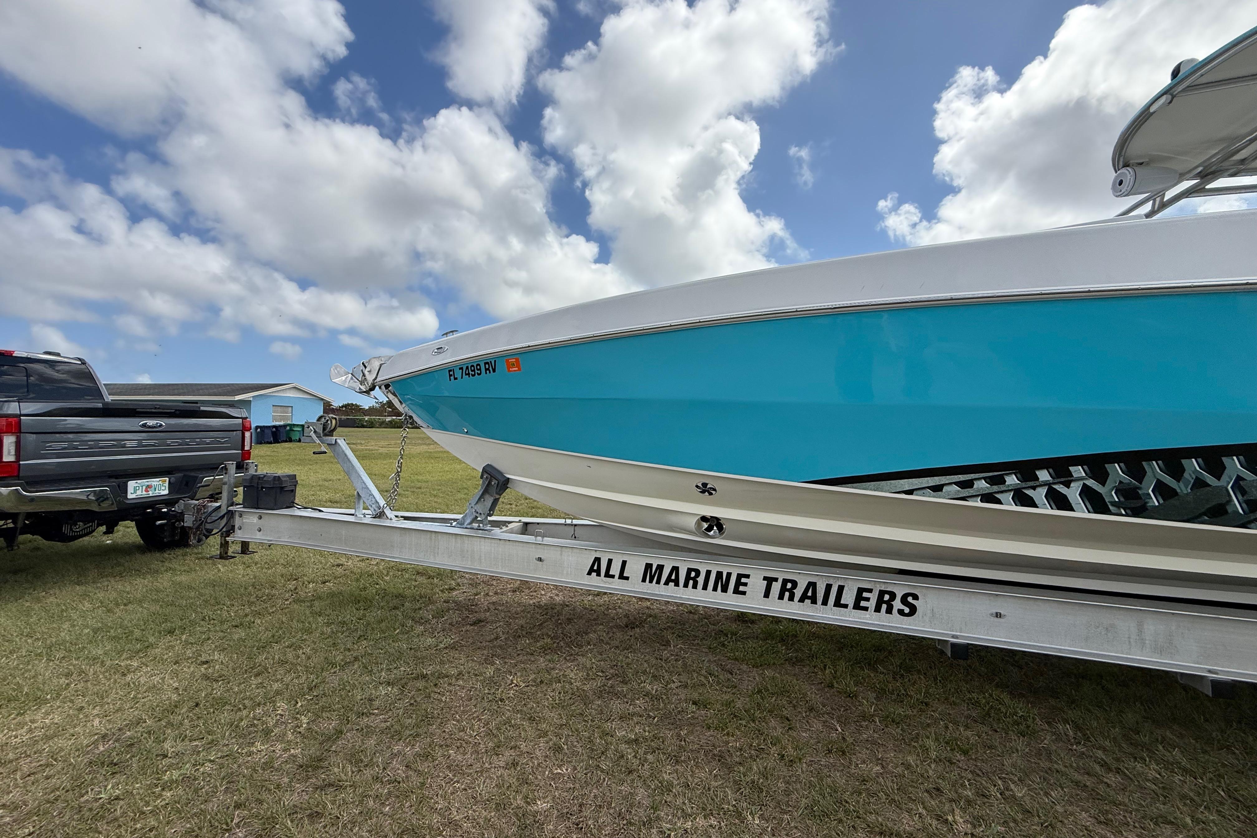 2016 Extreme Boats XC 38 Express on trailer, parked on grass under cloudy sky.