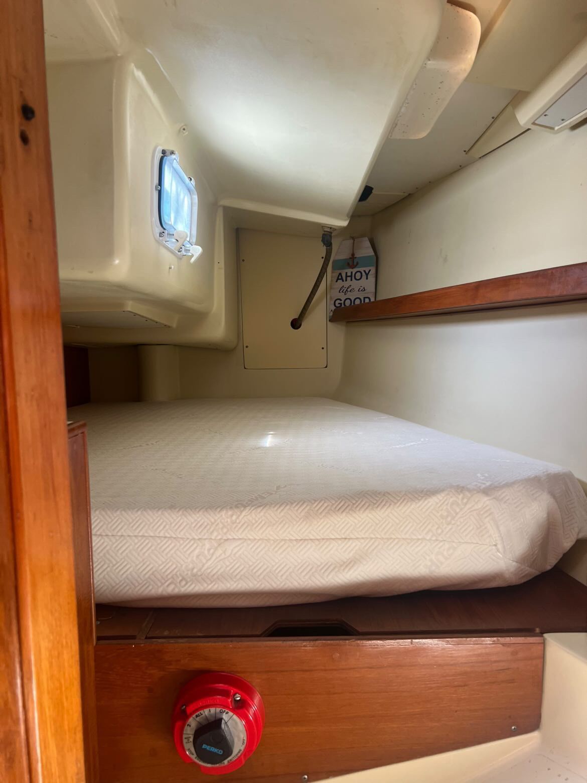 Interior of a 1988 Pearson 28 with a bed and a porthole.