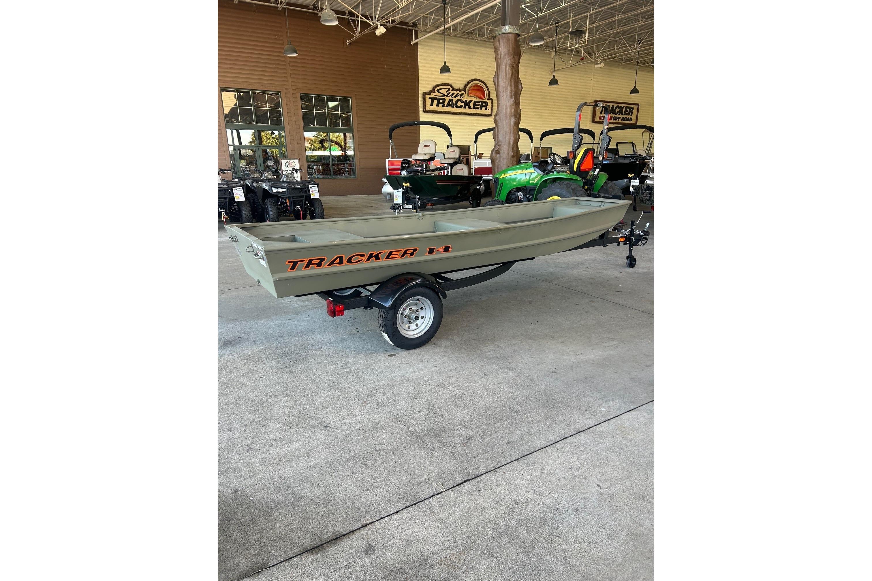 2026 Tracker Grizzly 14 Jon boat on trailer in showroom setting.