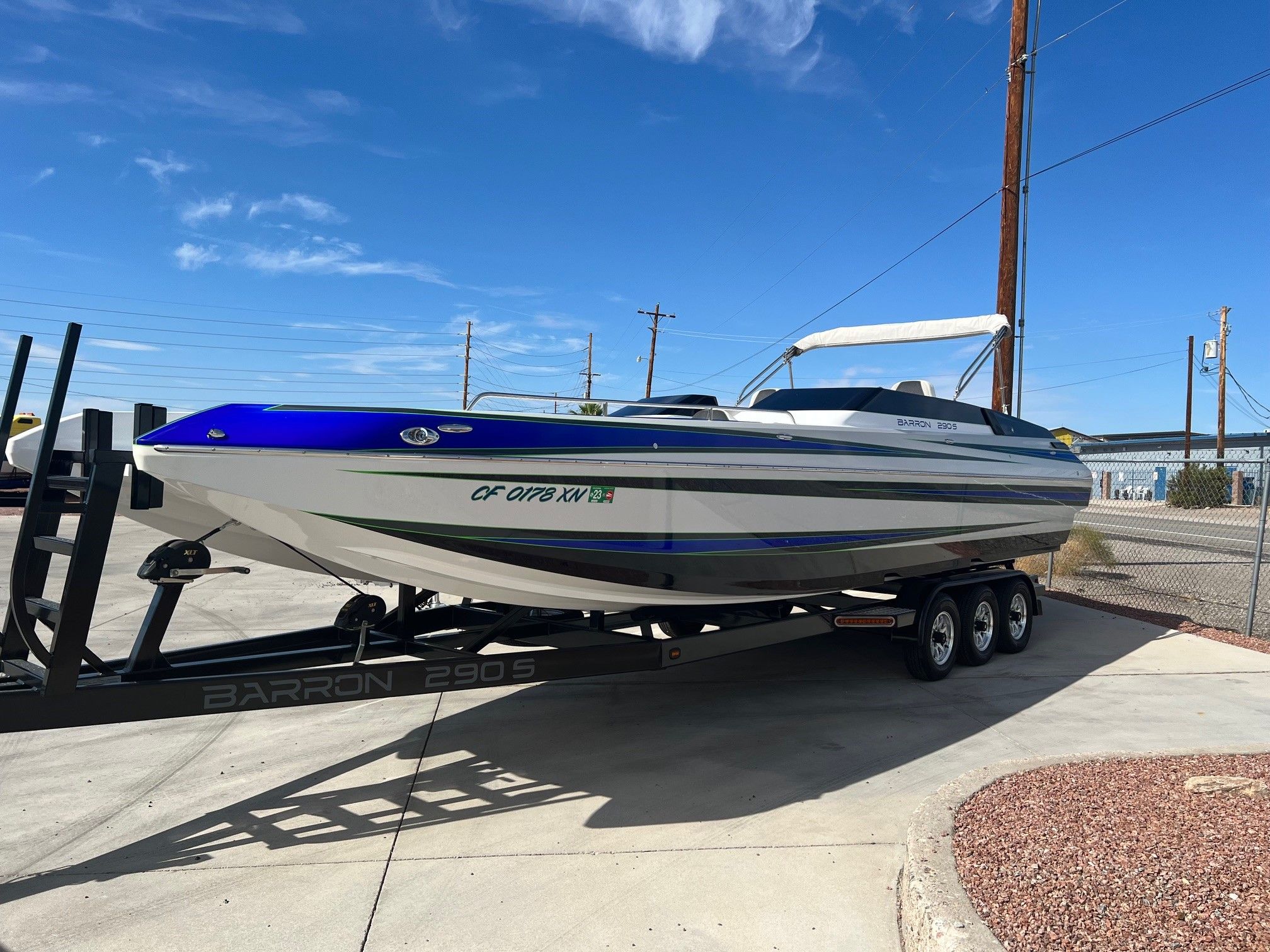 Custom Barron 290s boat from 2021 on trailer under blue sky.
