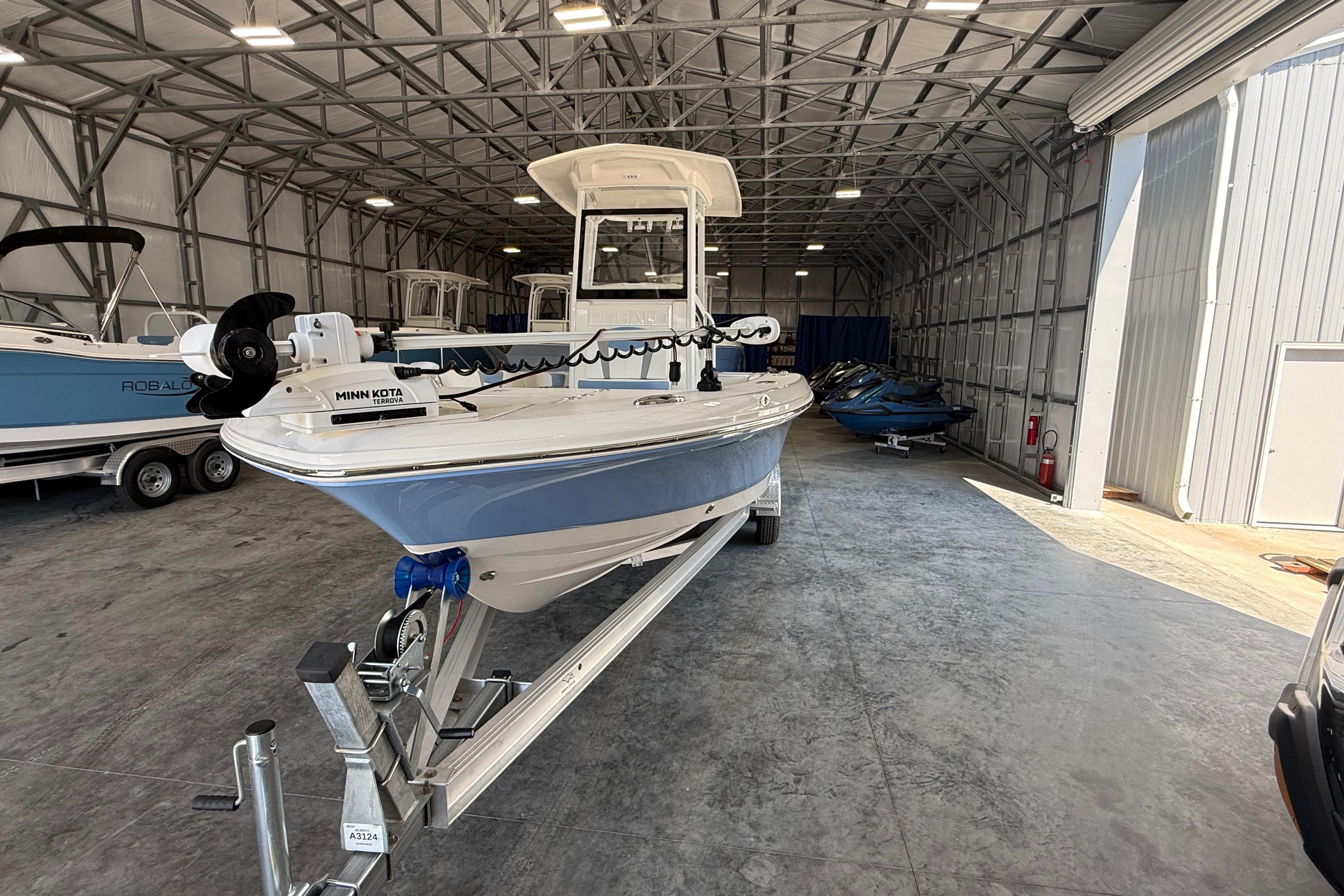 2026 Robalo 246 Cayman boat in a storage facility, featuring a Minn Kota trolling motor.