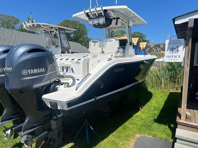 A 2023 Pursuit S268 boat is on a lawn next to a building.