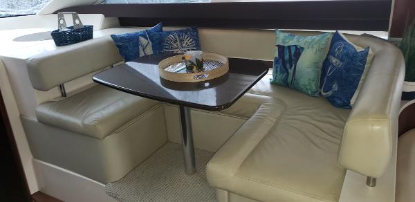 Luxurious interior of 2010 Meridian 441 Sedan yacht with cozy seating and decorative pillows.