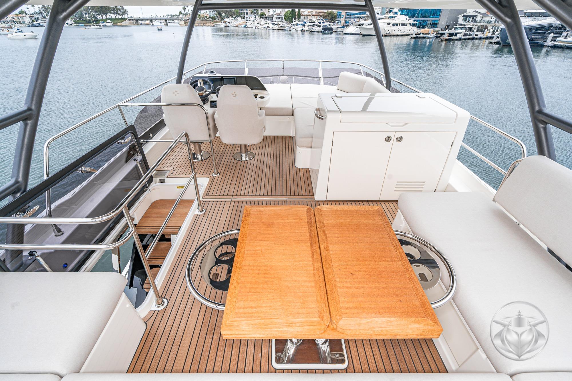 Luxurious 2026 Prestige F5.7 yacht interior with elegant seating and wooden table.