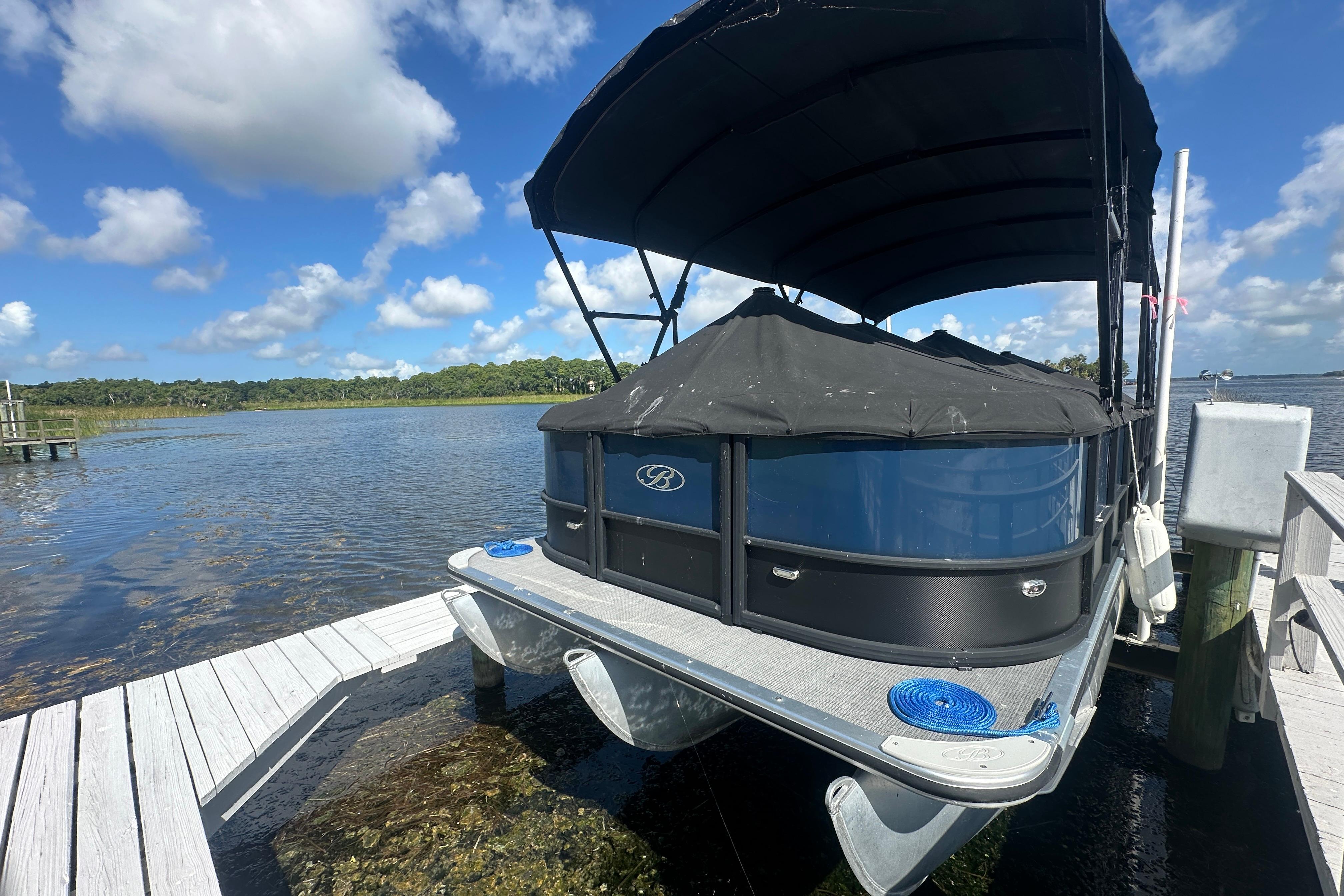 2023 Bentley Pontoons Legacy 243 Swingback docked on a sunny day by the lake.