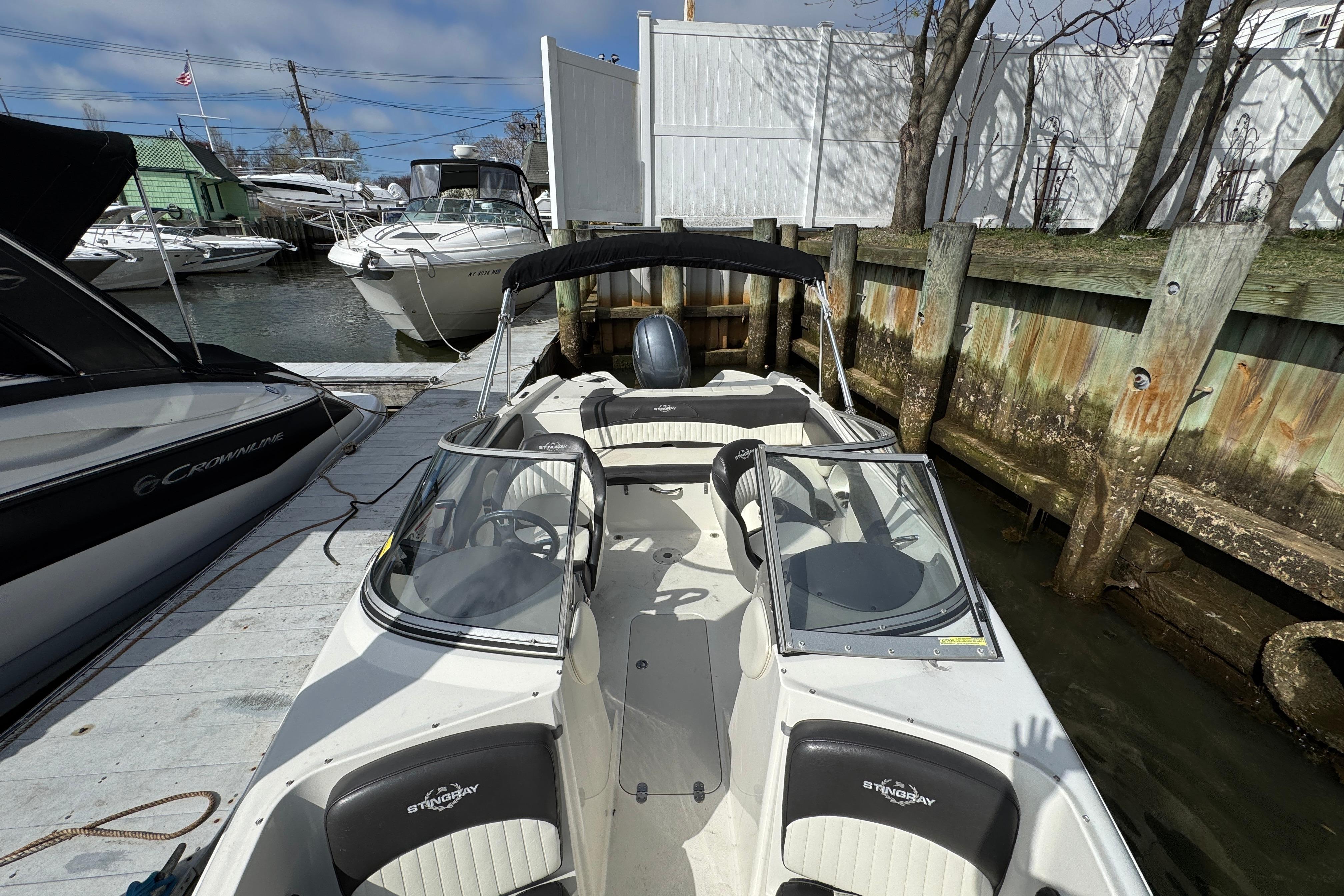 2019 Stingray 204 LR boat docked, featuring sleek design and spacious seating.
