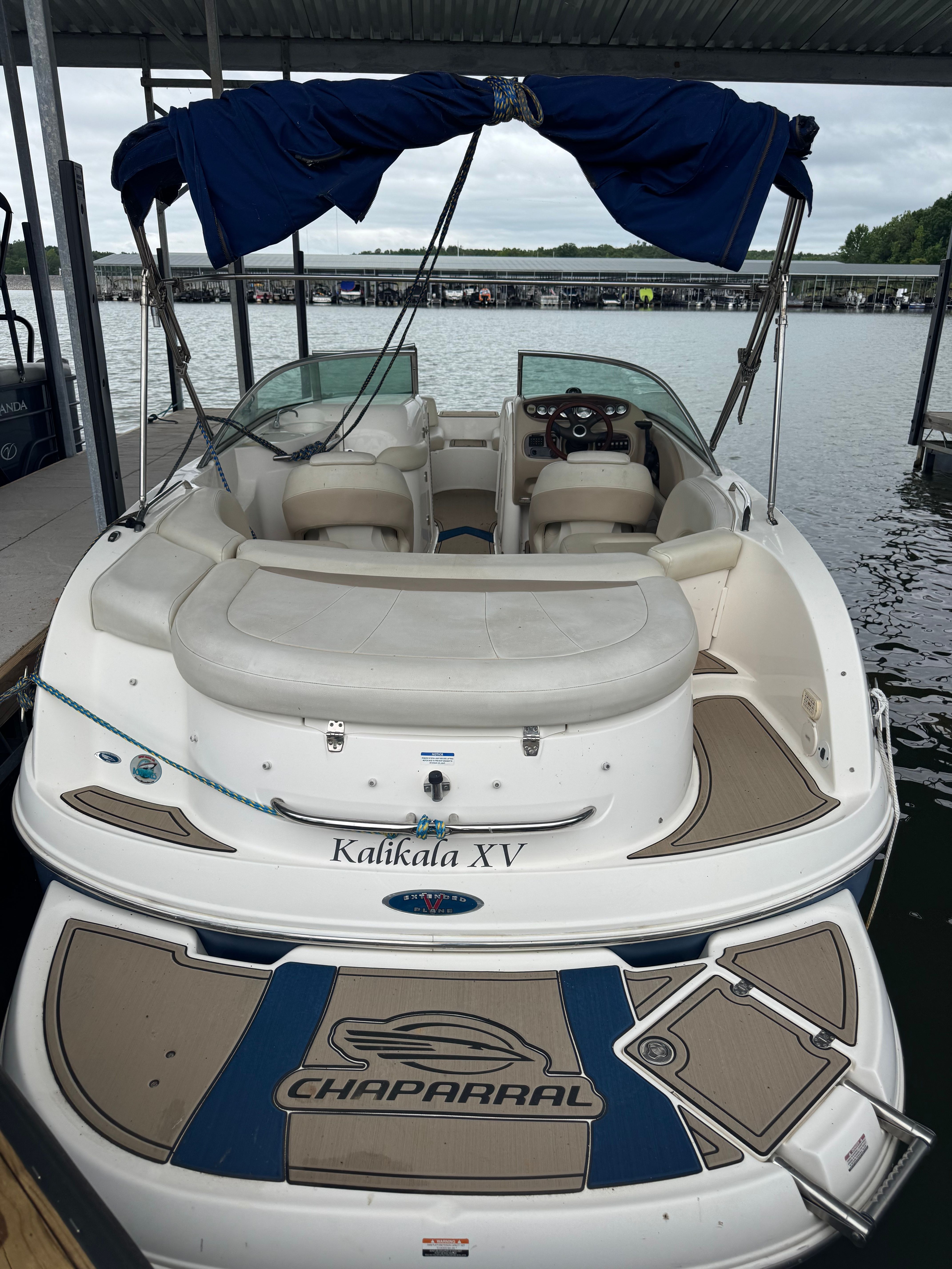 A 2003 Chaparral Sunesta 223 boat is docked on the water.