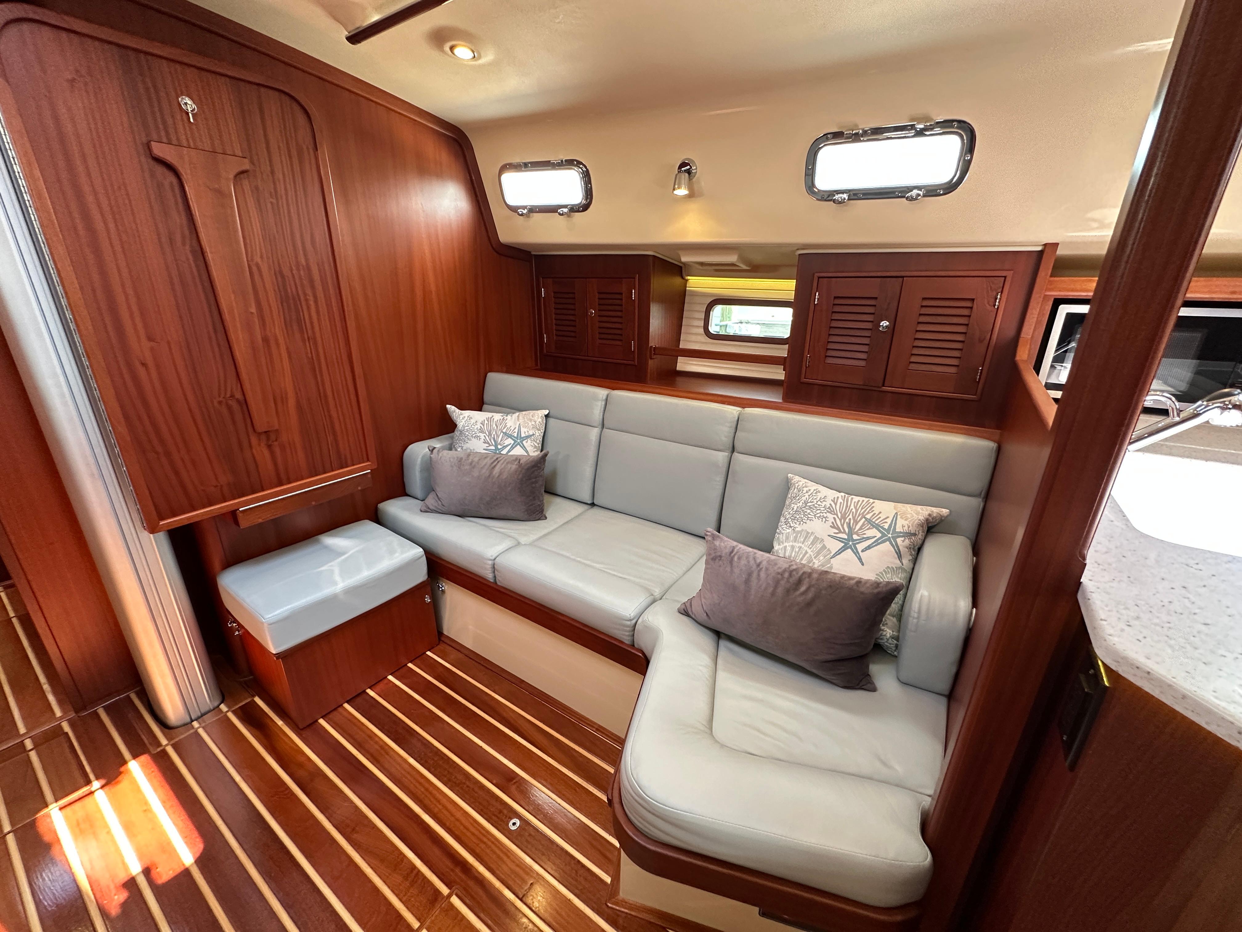 Luxurious interior of 2021 Island Packet 439 yacht with elegant wood finish and comfortable seating.