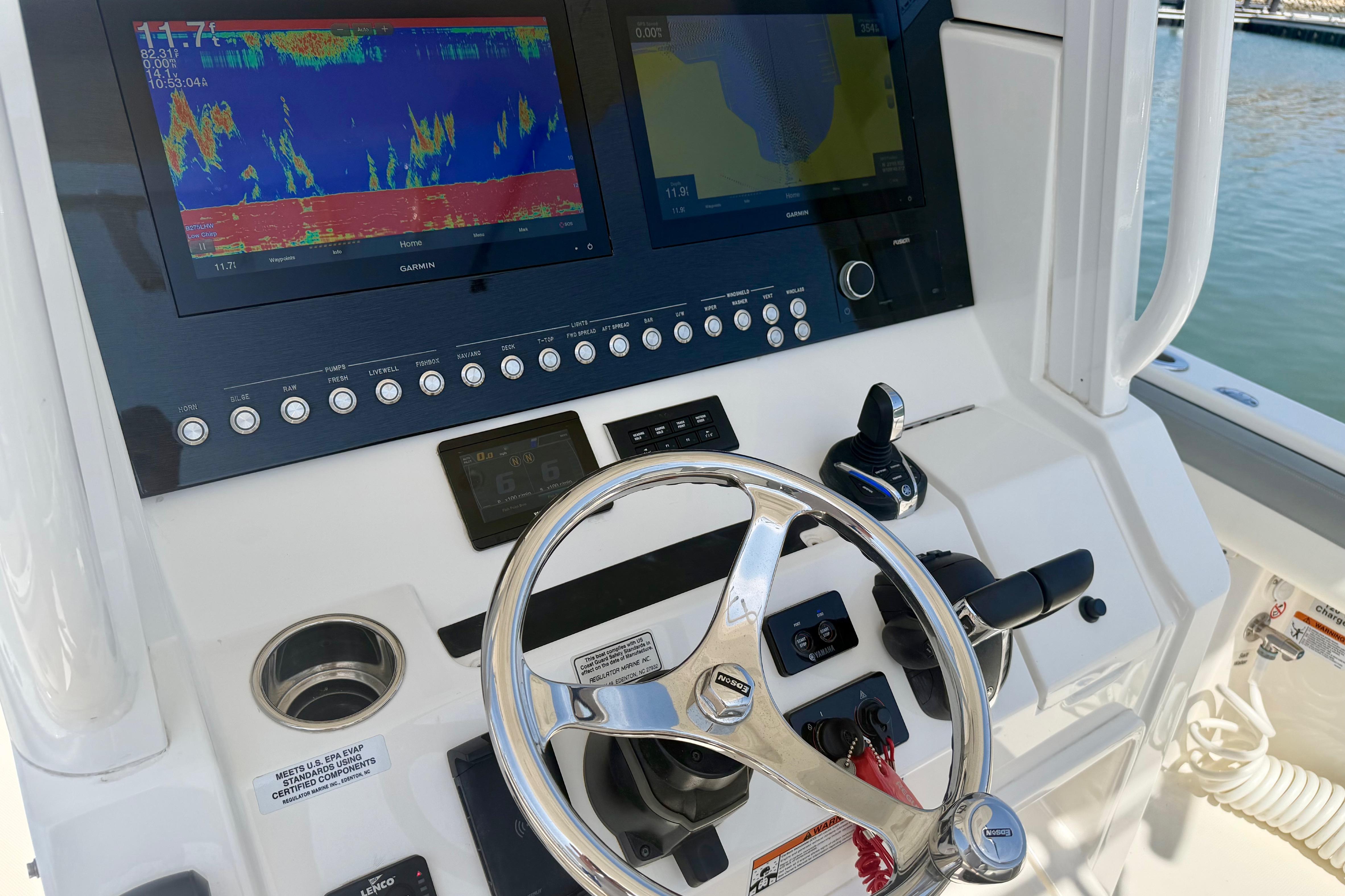 Helm of 2022 Regulator 28 boat with advanced Garmin navigation displays and controls.
