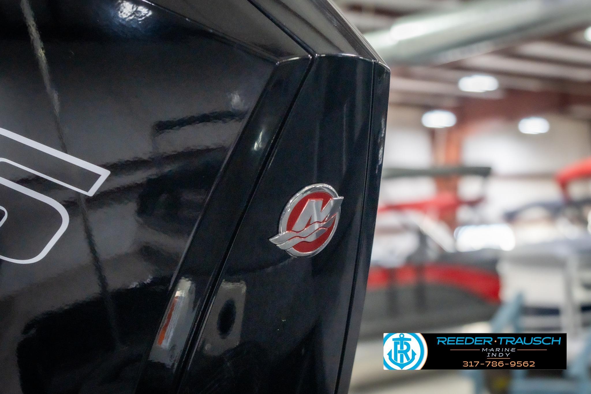 2026 Lund 2075 Impact XS boat detail with logo in showroom setting.