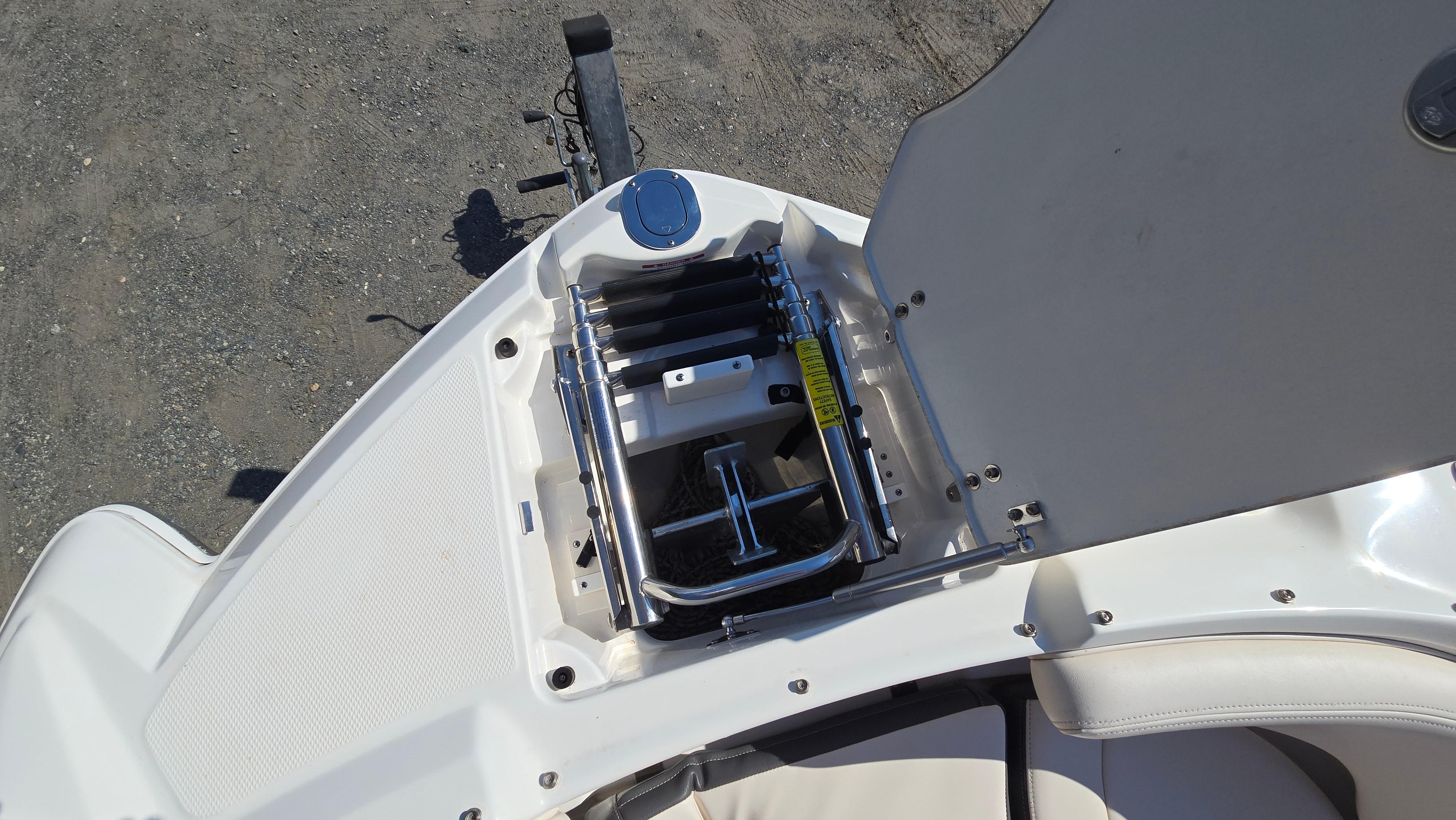 2018 Chaparral 224 Sunesta boat with open storage compartment and ladder.