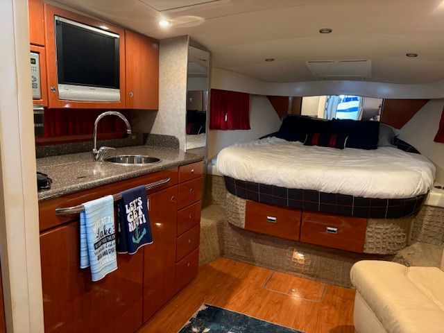 Interior of a 2007 Formula 34 Performance Cruiser with cozy bed, kitchenette, and TV.