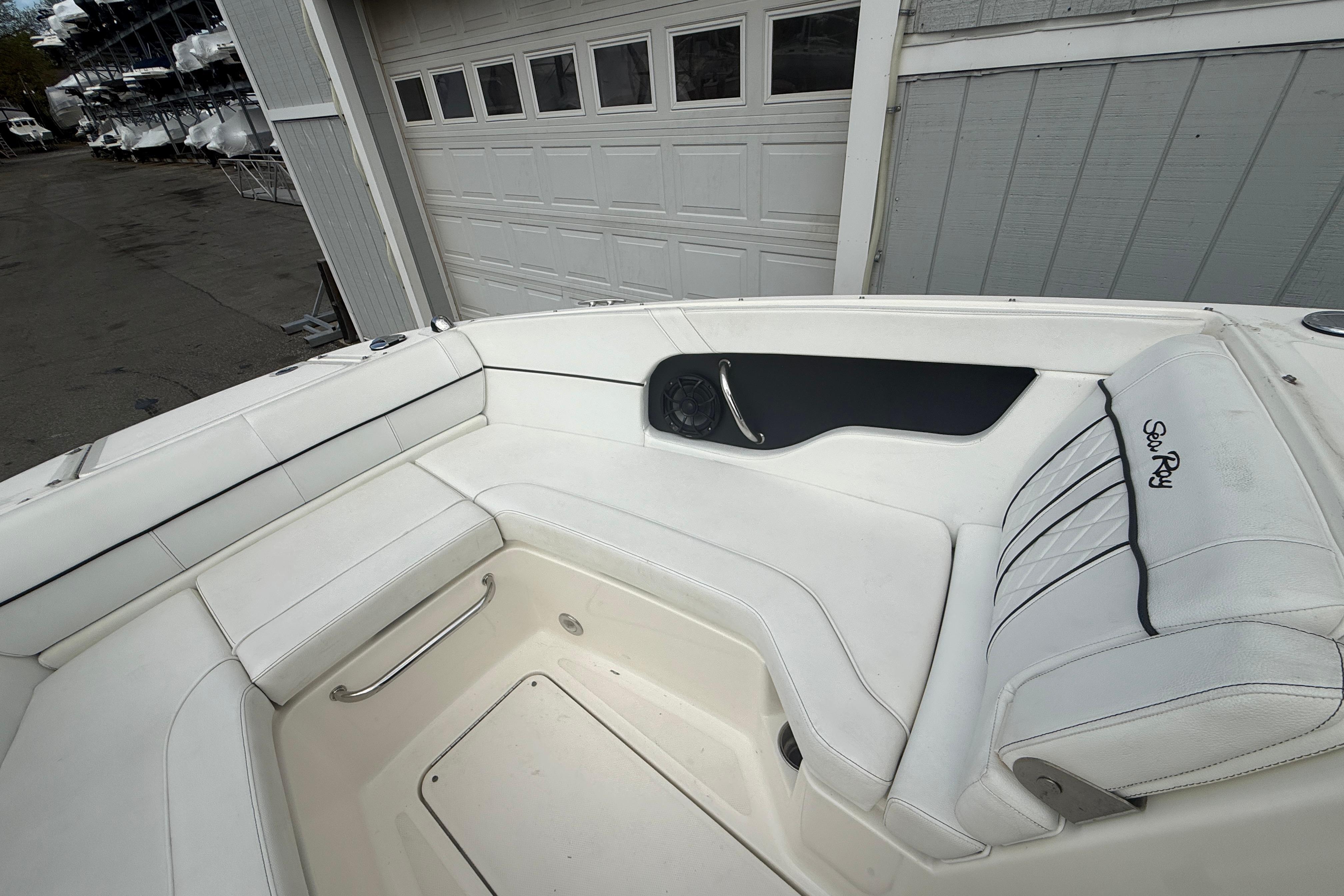 2015 Sea Ray 240 Sundeck boat interior with white seating and storage compartment.