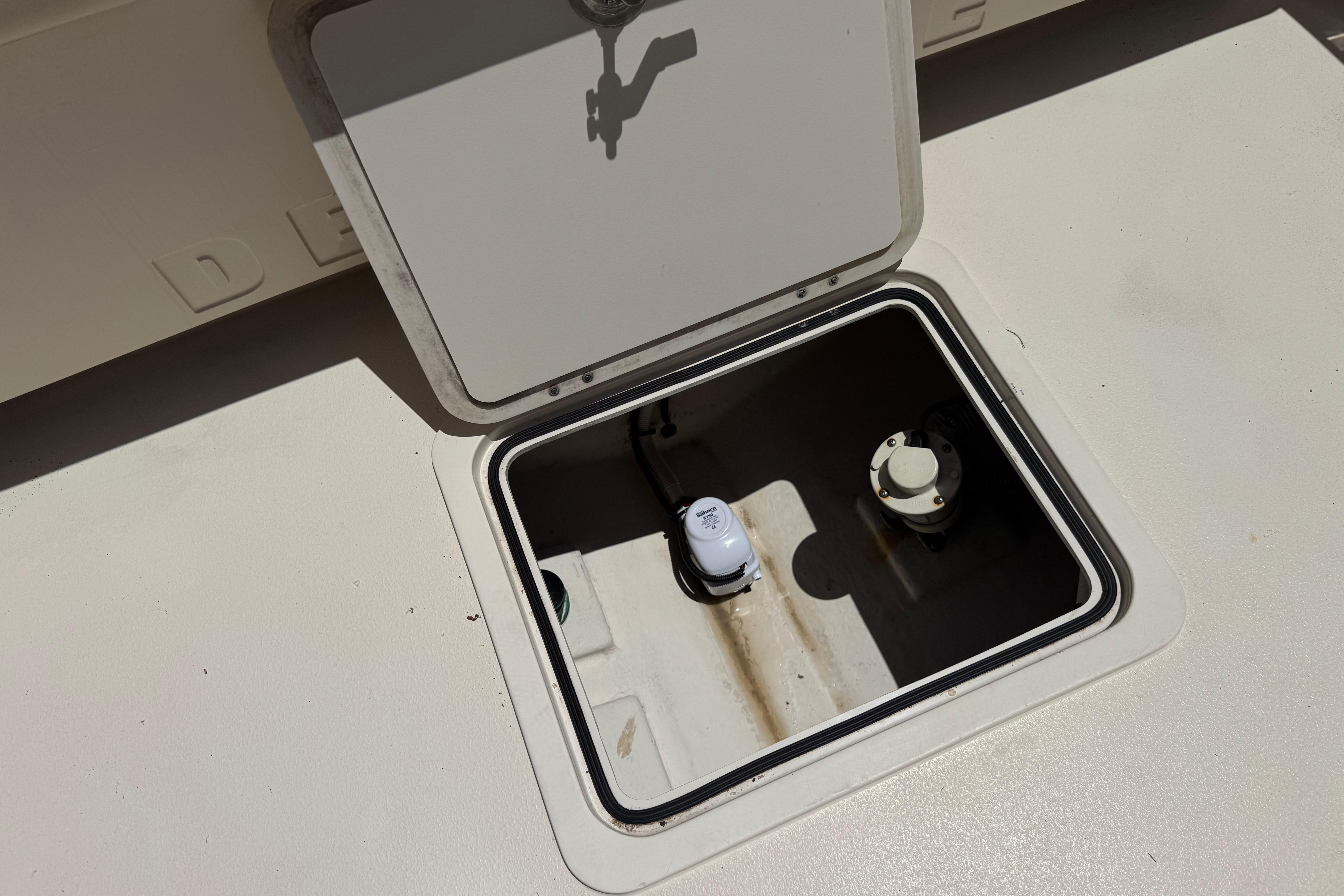 Open hatch on 2017 Defiance Admiral 220 EX boat deck, revealing interior components.