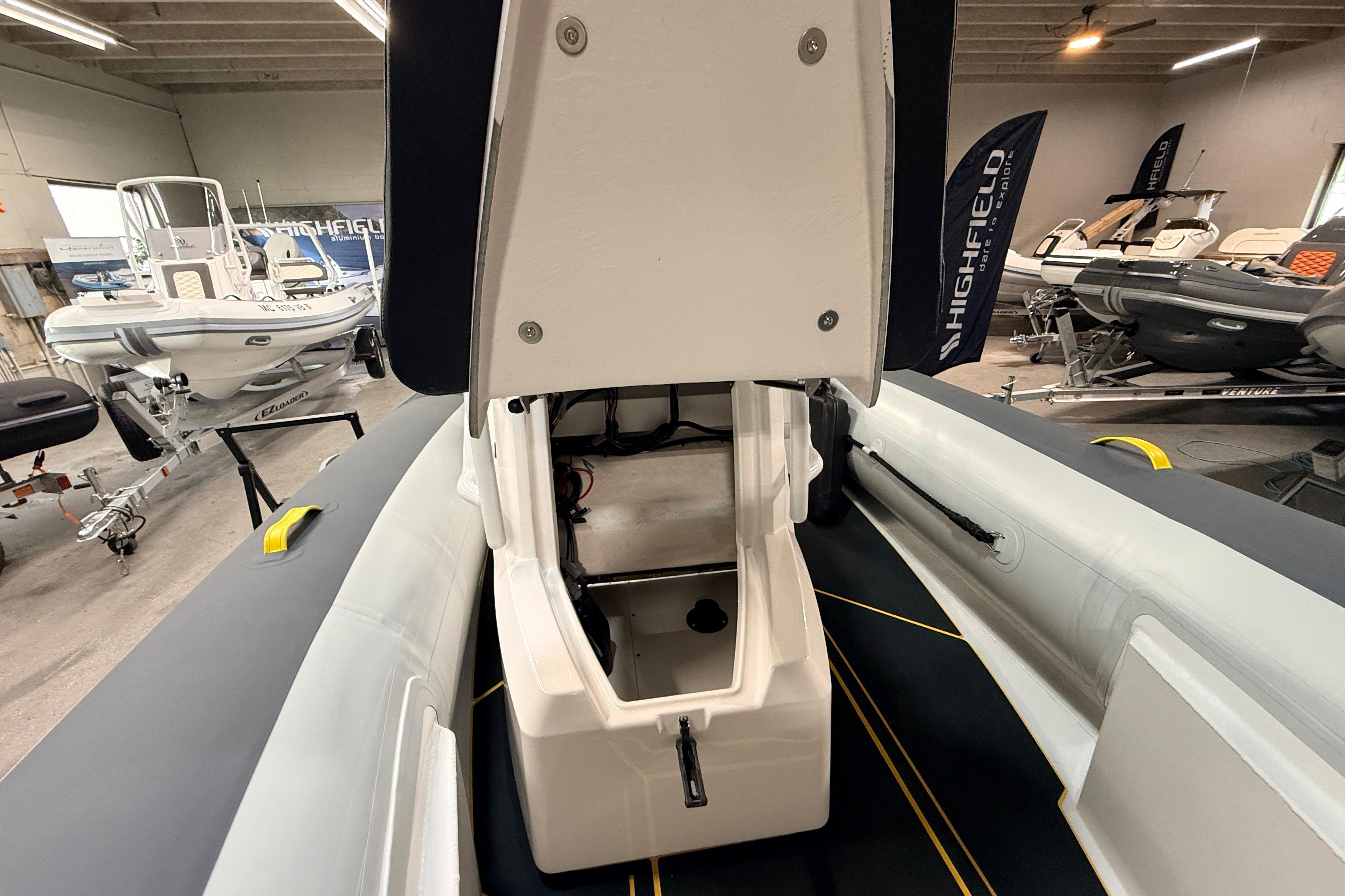 2026 Highfield VELOX 560 boat interior with open storage compartment in showroom.