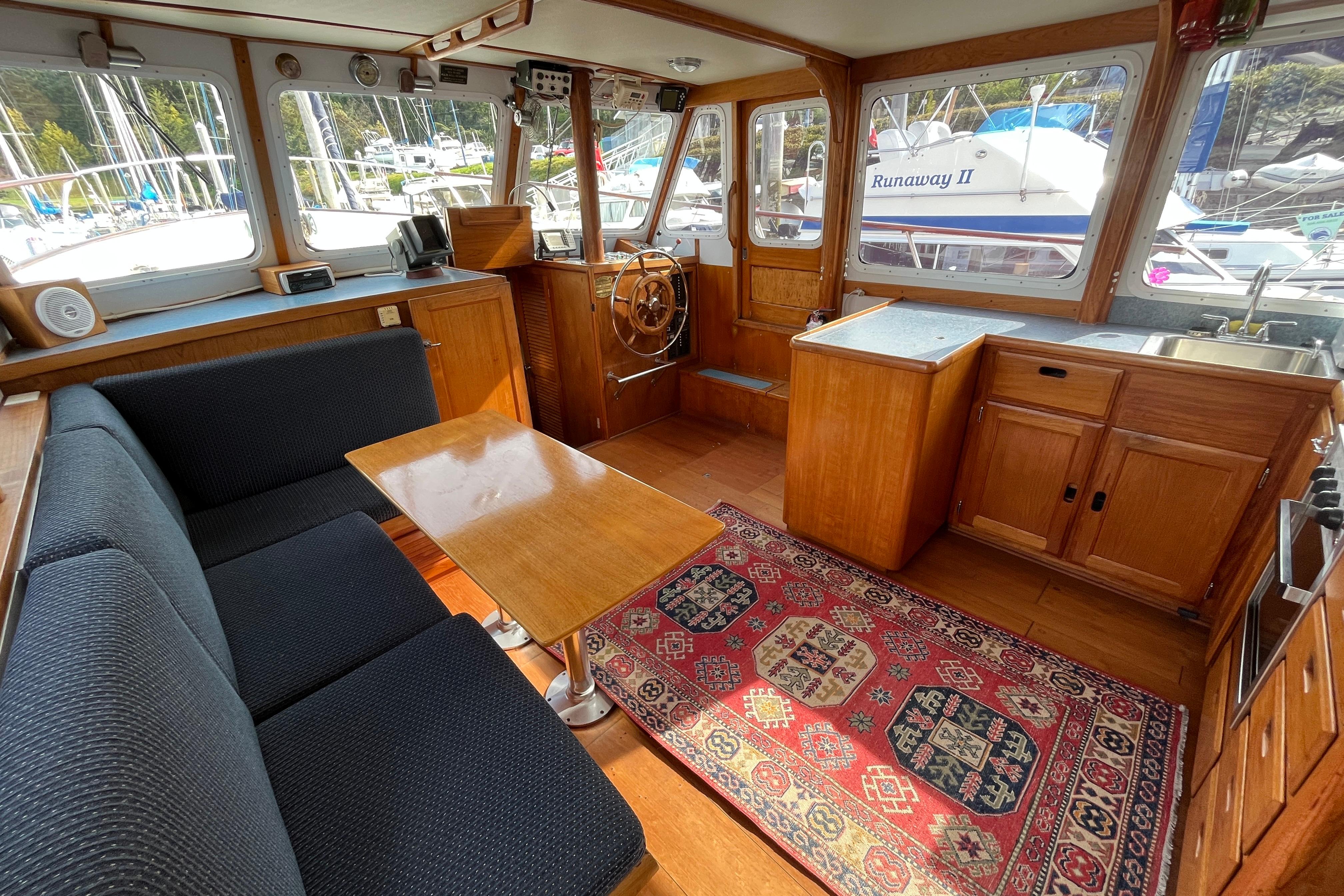 Interior of a 1974 DeFever 40 yacht with cozy seating and nautical decor.