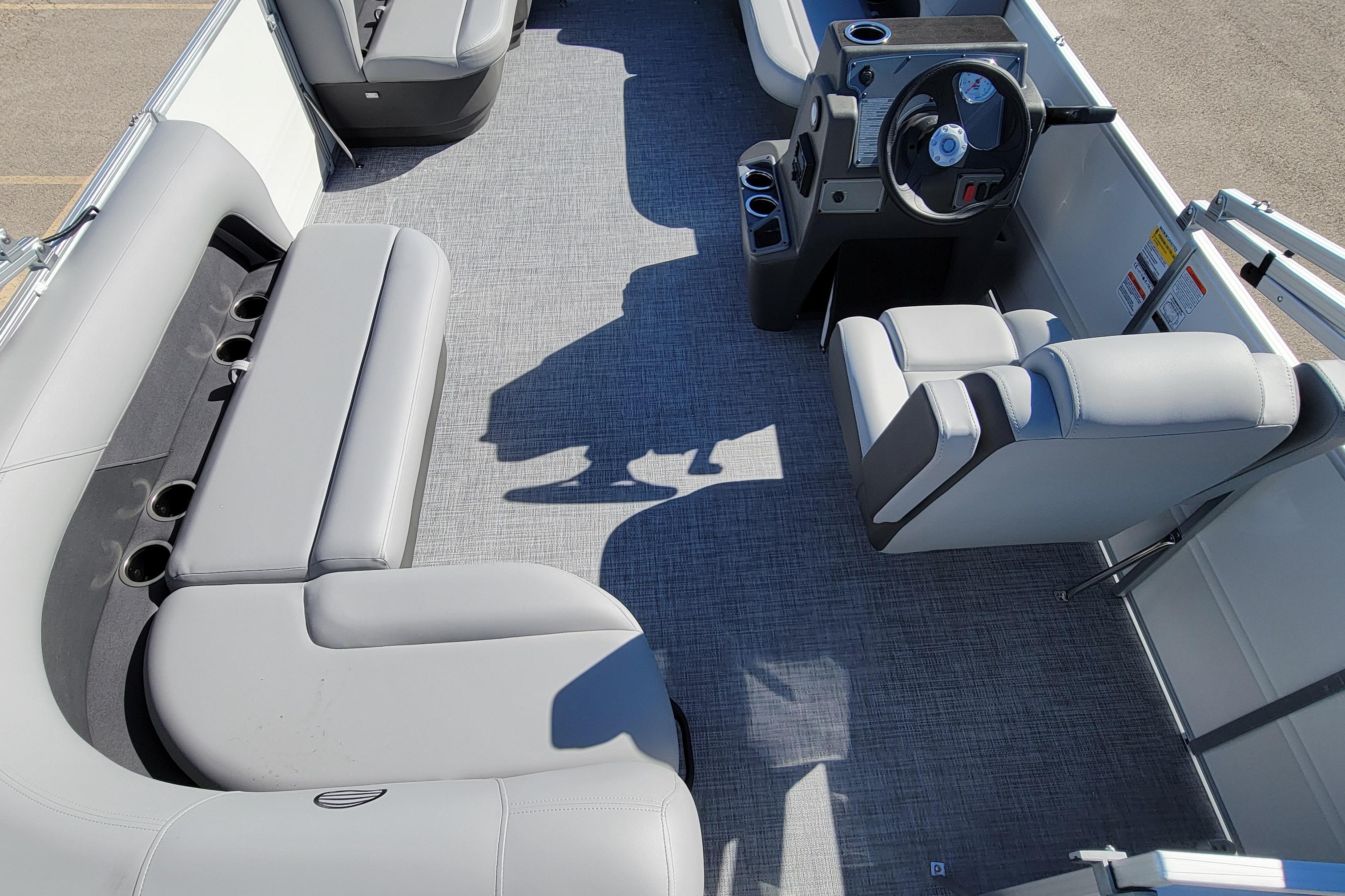 2026 Sun Tracker Party Barge 16 DLX interior with gray seating and steering console.