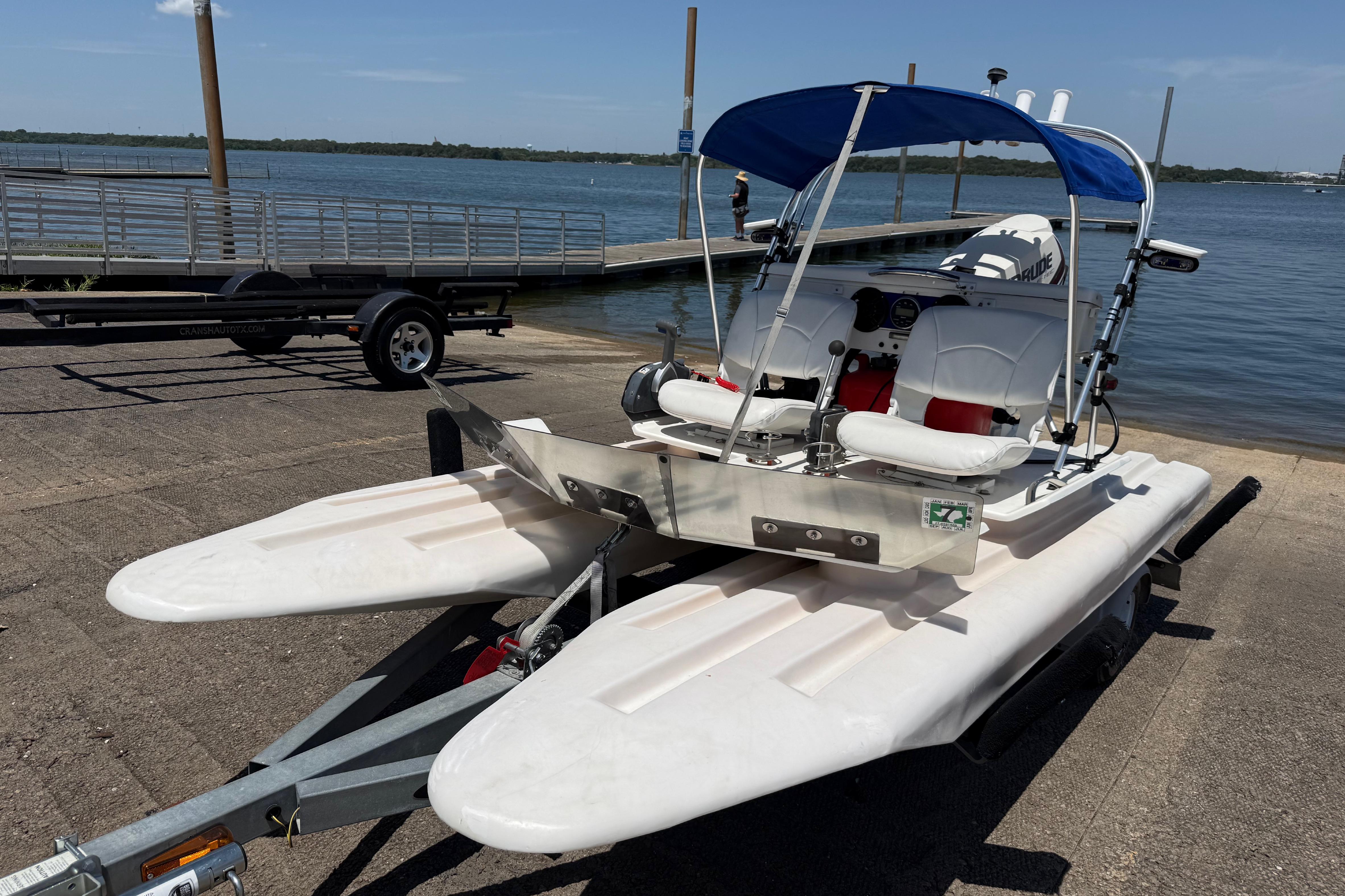 2016 CraigCat E2 Elite catamaran on trailer by a lakeside dock.