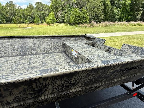2025 Tracker GRIZZLY 2072 Utility boat with camouflage design in a scenic outdoor setting.