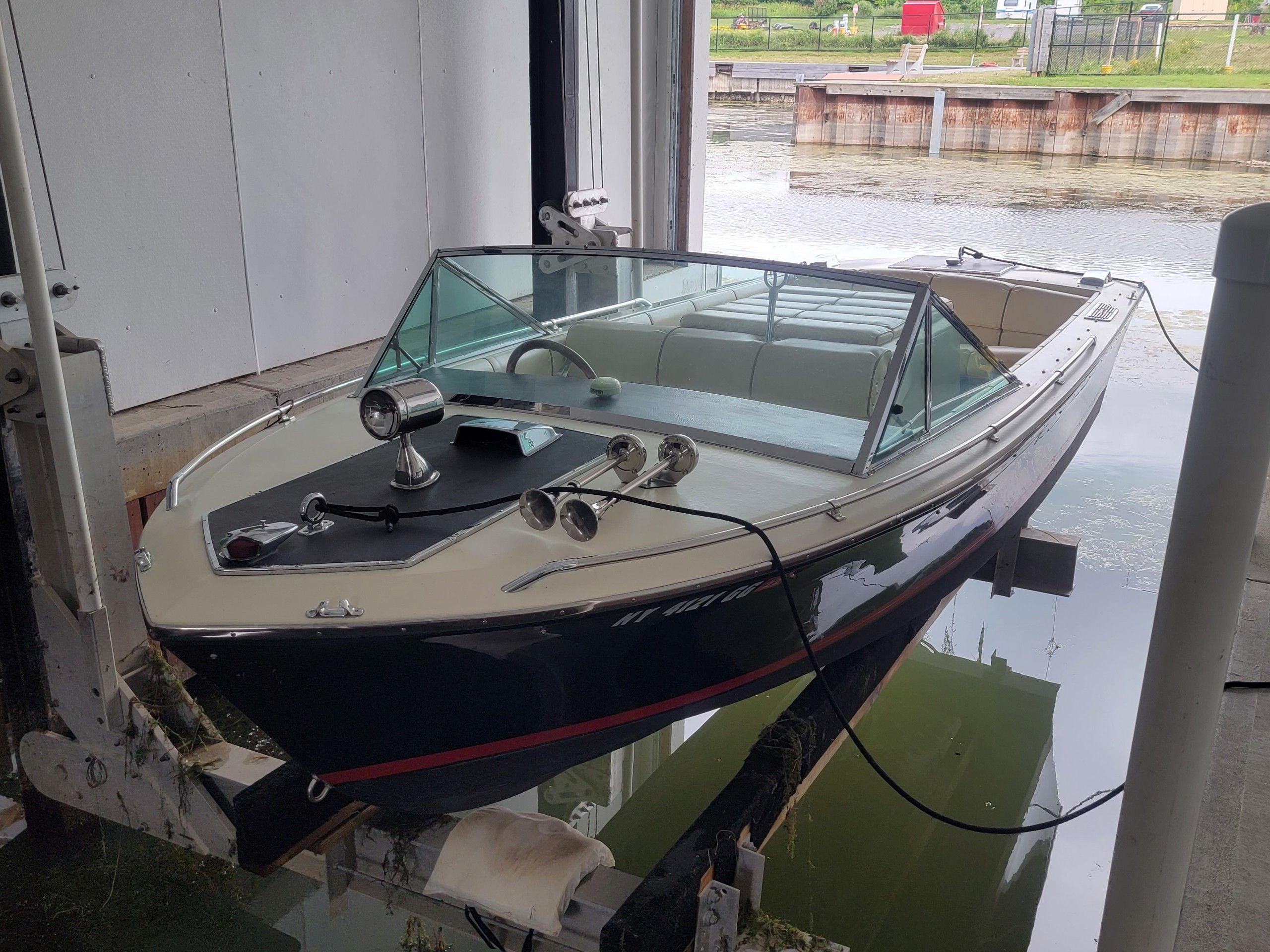 1986 Century Resorter boat in a dock by the water.