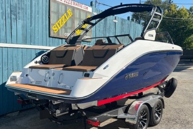 2026 Yamaha Boats 222SE on trailer, blue and white design, parked outdoors.