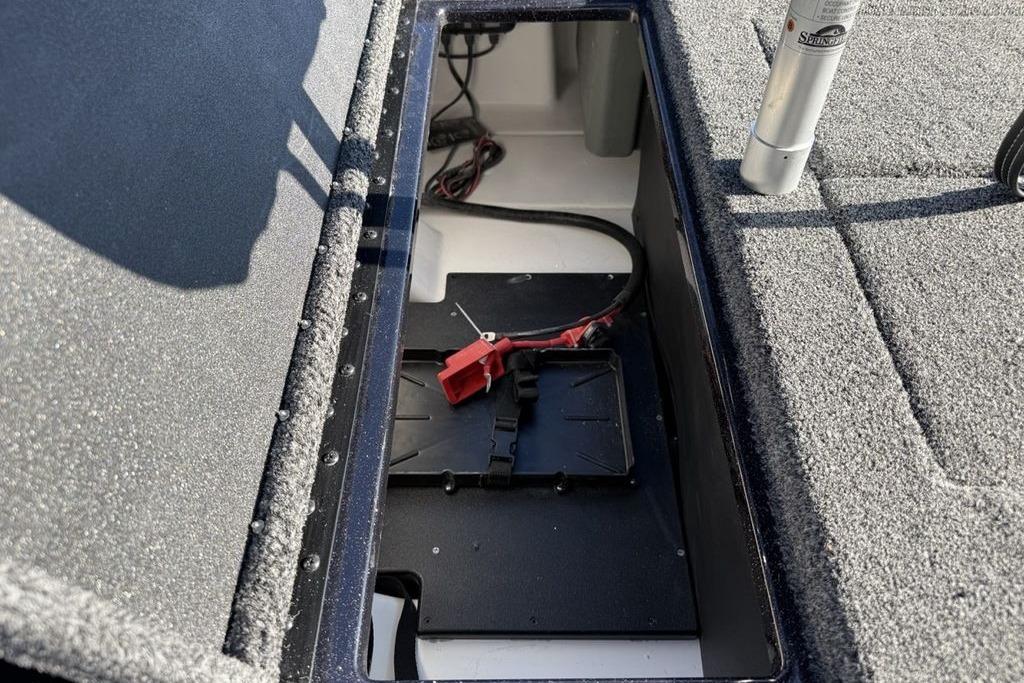 Open storage compartment in 2026 Nitro Z17 boat, featuring wiring and carpeted interior.