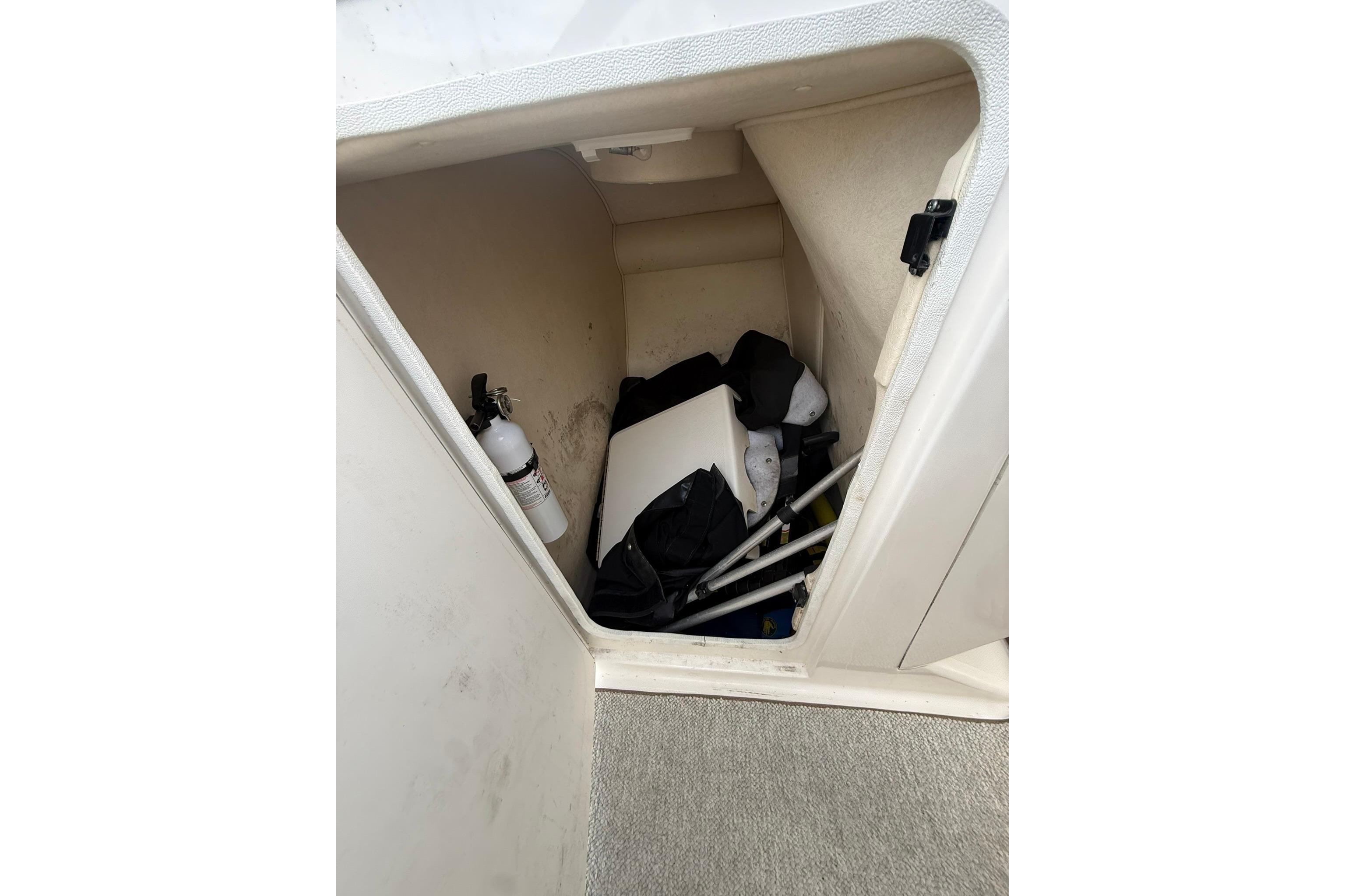 Storage compartment of a 2005 Sea Ray 290 SLX boat with safety equipment.