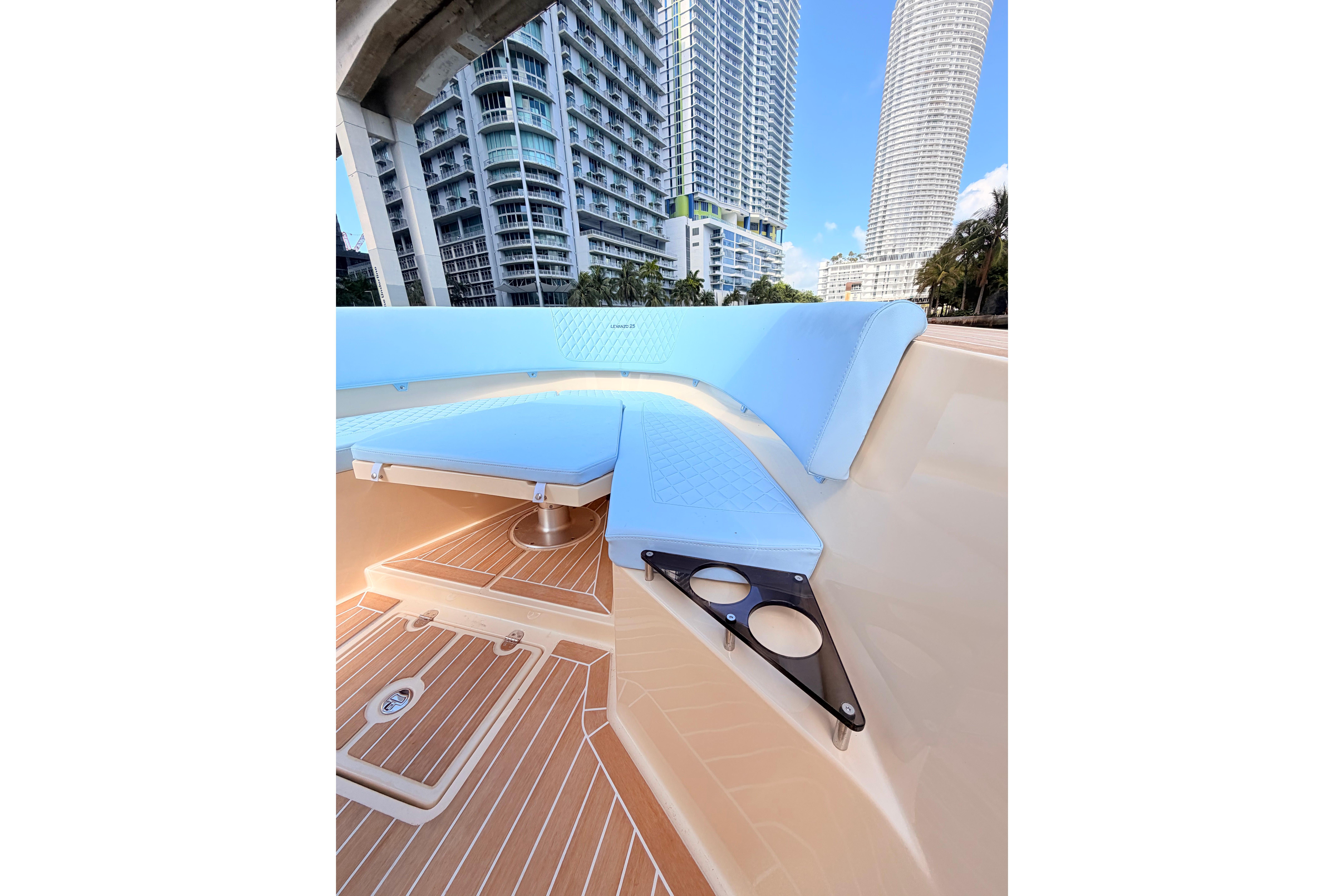 Luxury Lilybaeum Levanzo 25 boat interior with modern seating, cup holders, and cityscape view.