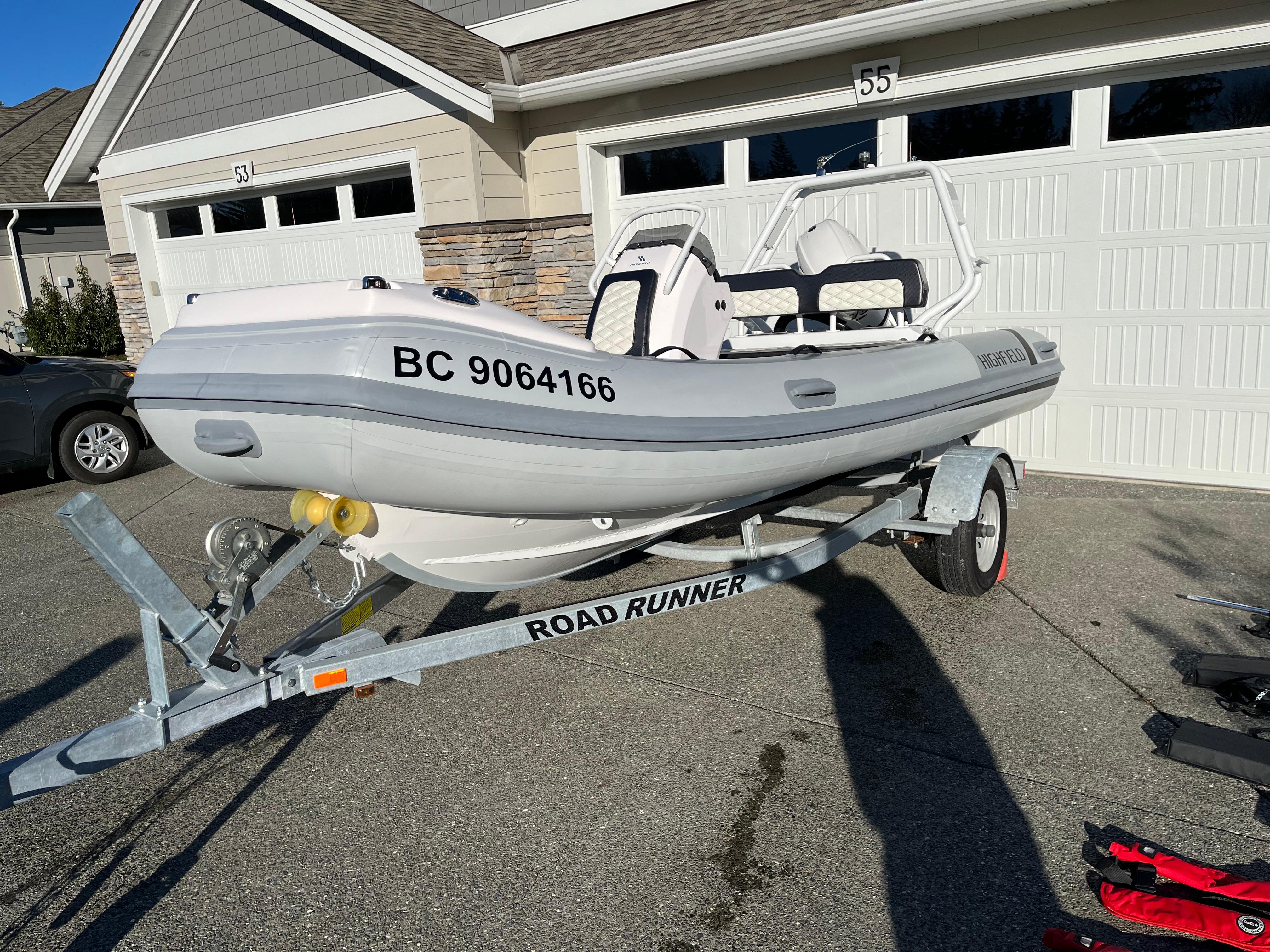2023 Highfield Sport 420 inflatable boat on trailer, parked in driveway.