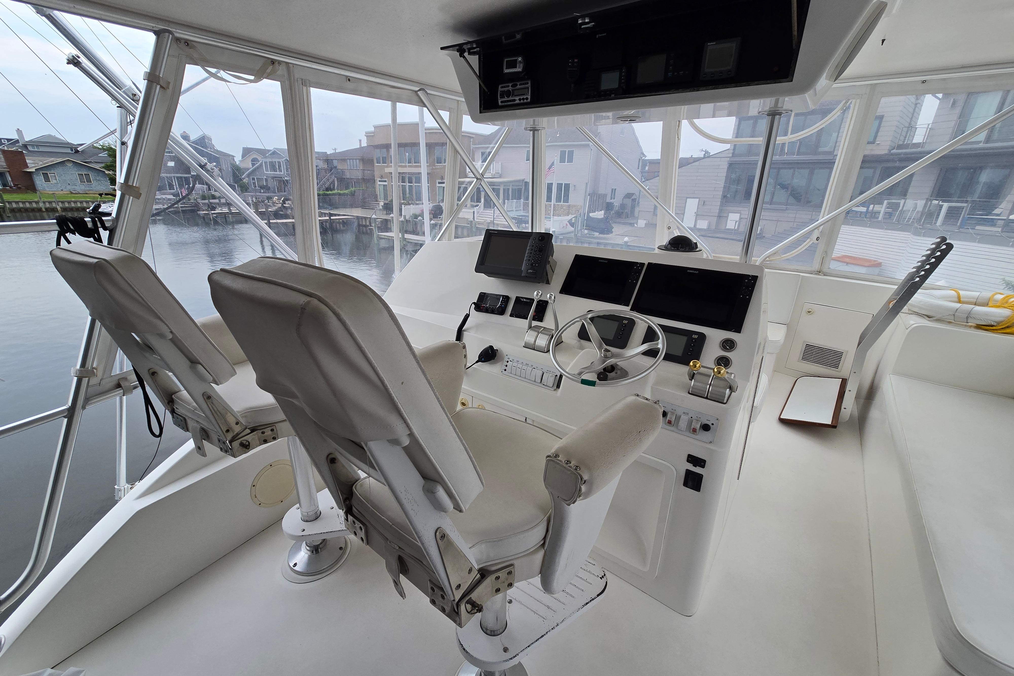 Interior of a 2001 Cavileer 53 Convertible yacht with dual captain chairs and navigation controls.