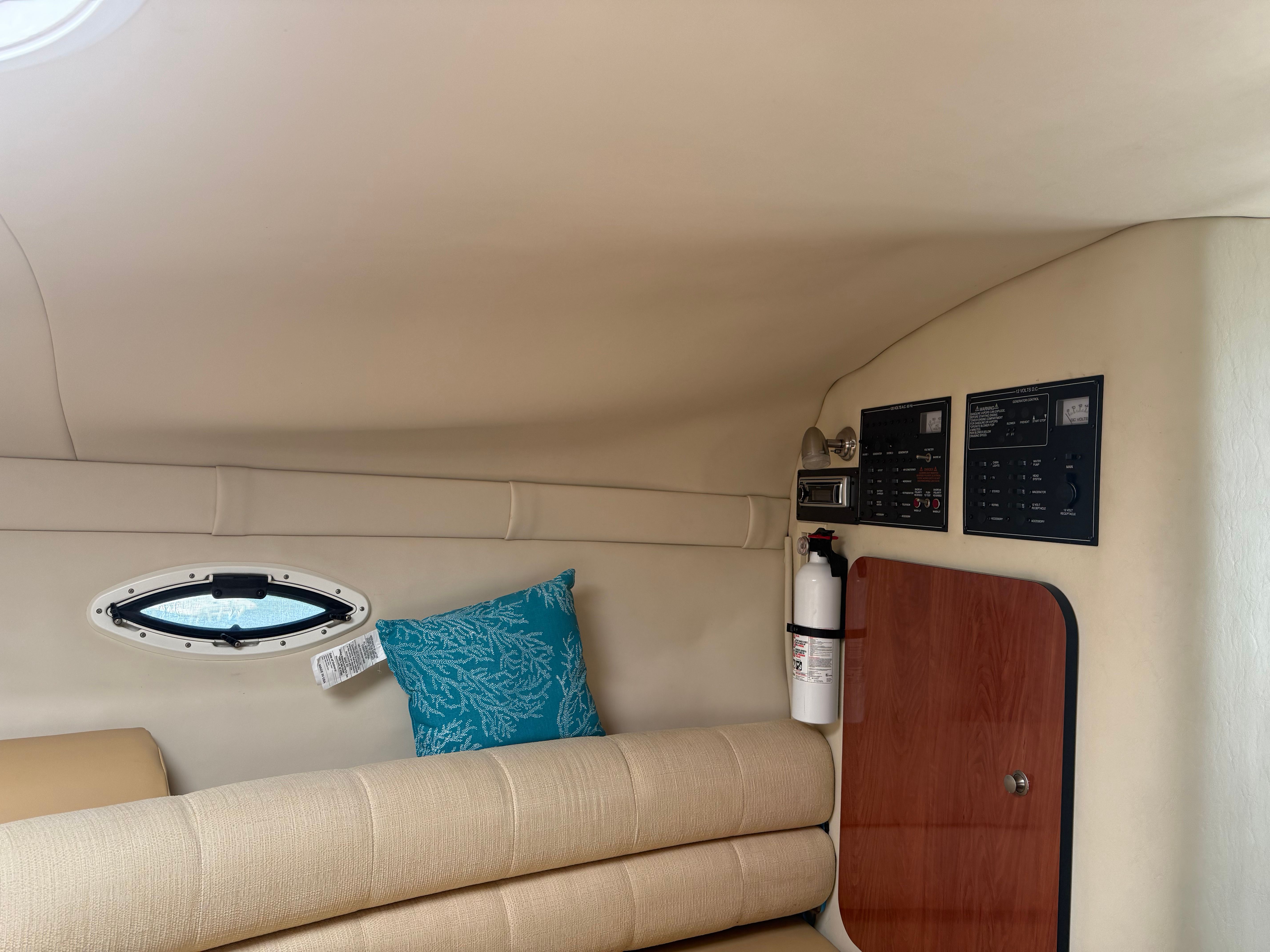 Interior of a 2006 Monterey 270 Cruiser with cream sofa and blue pillow.