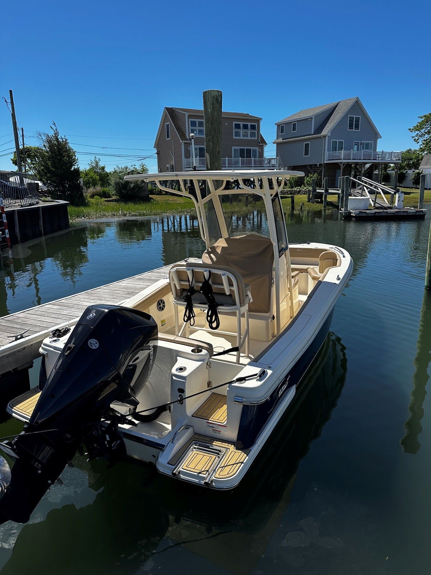 Scout 210XSF 2022 boat docked on calm water.